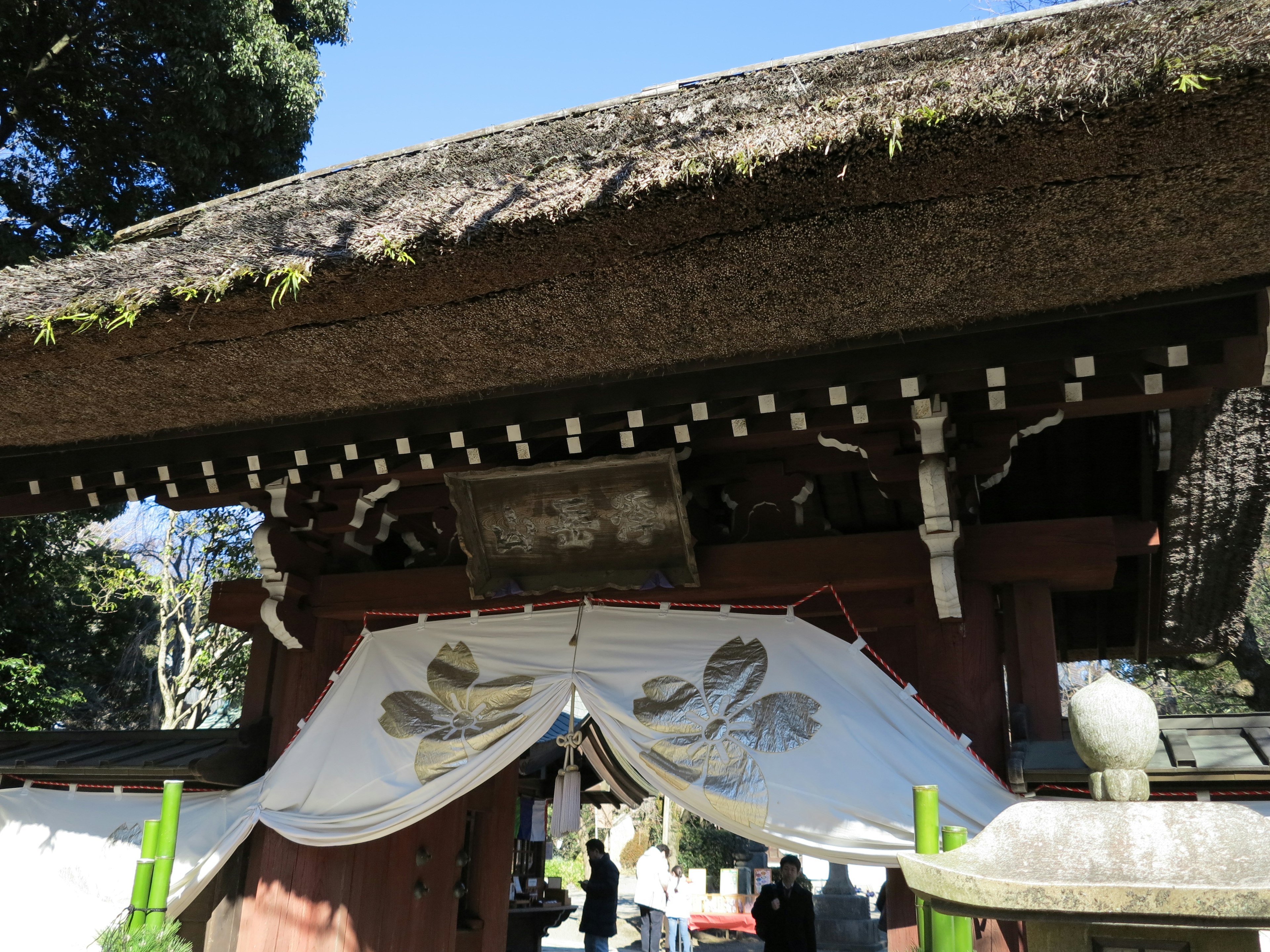 Traditional Japanese temple gate featuring a white curtain and roof details