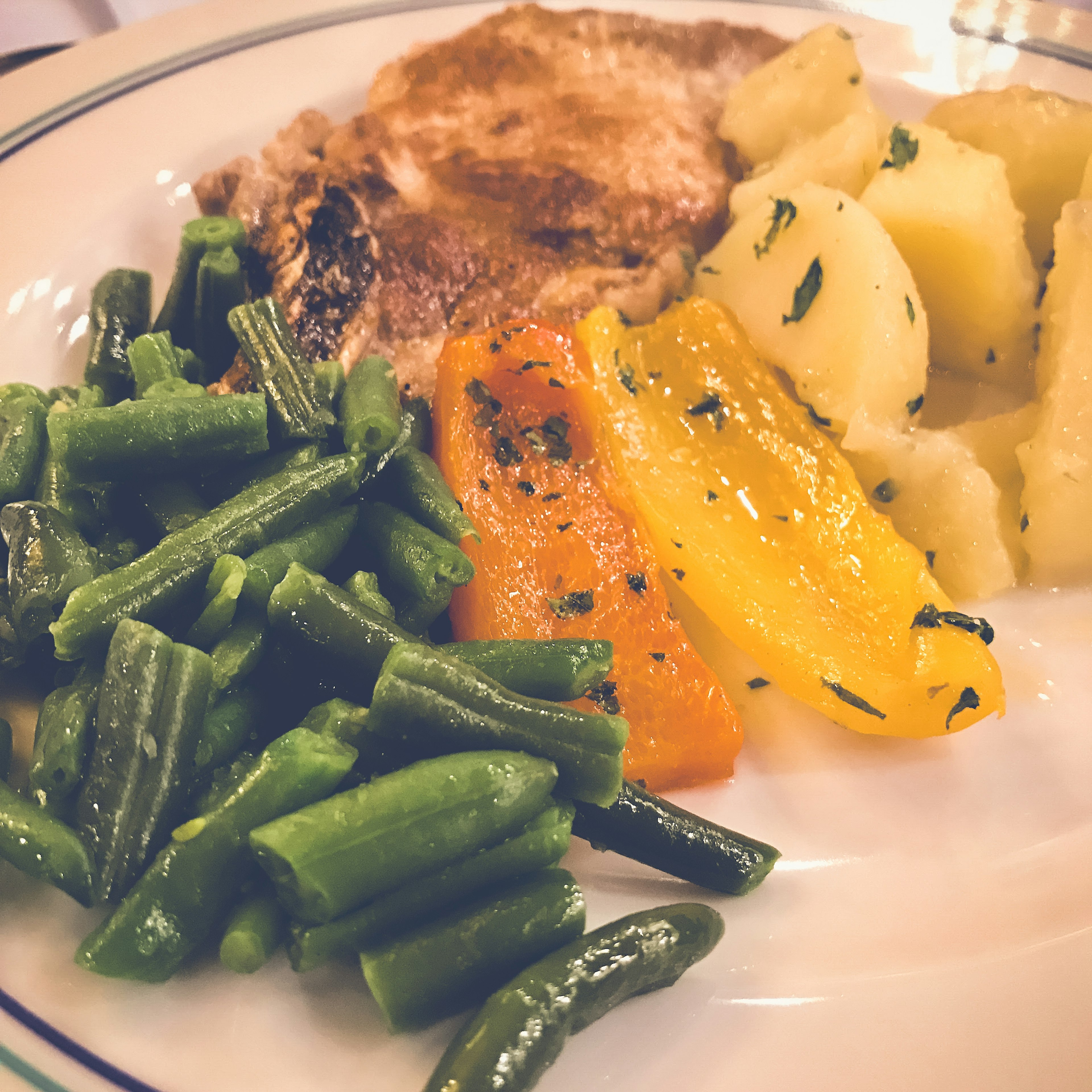 Un piatto con filetto di pesce patate lesse e verdure colorate