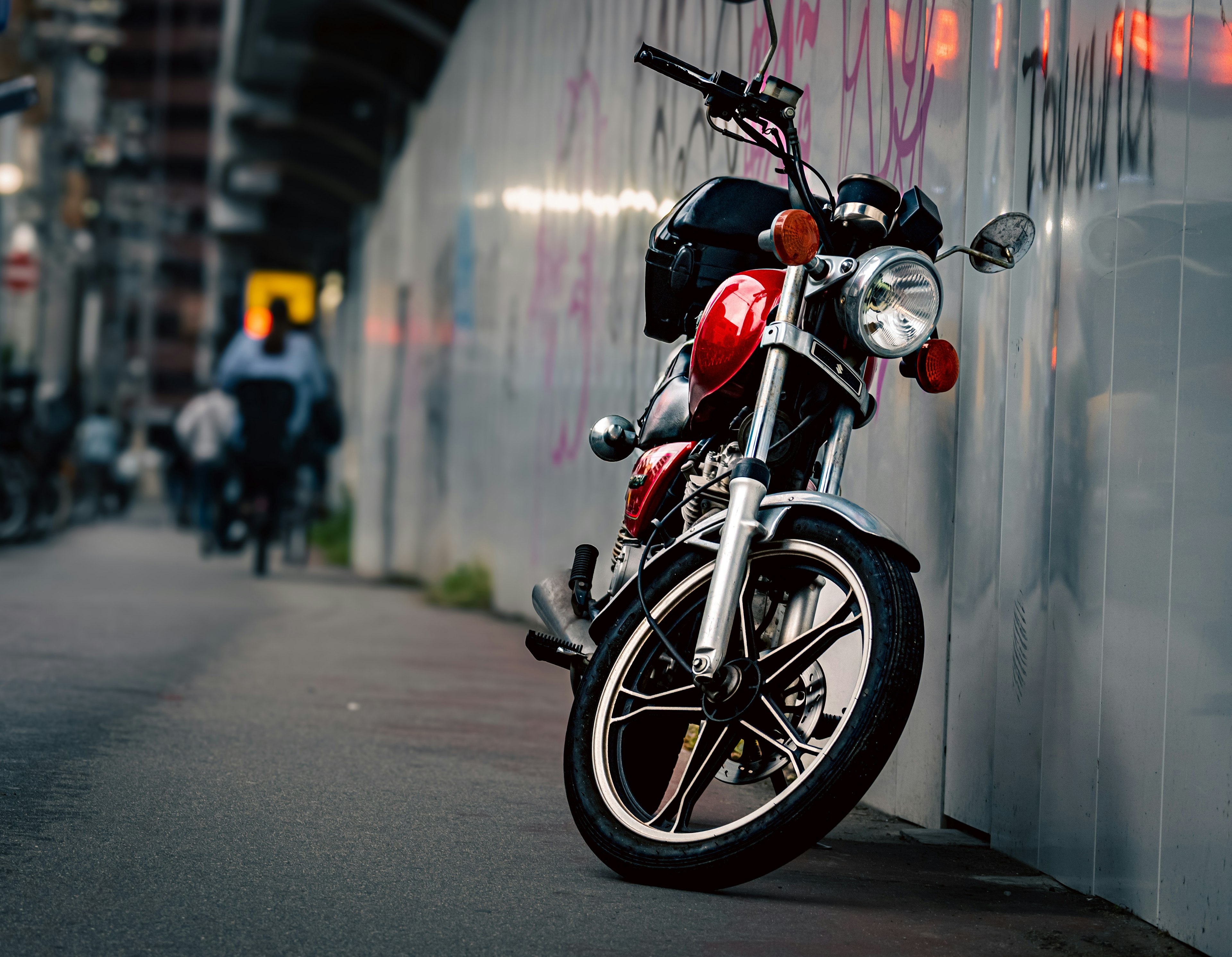 赤いバイクが壁に寄りかかっている街の風景