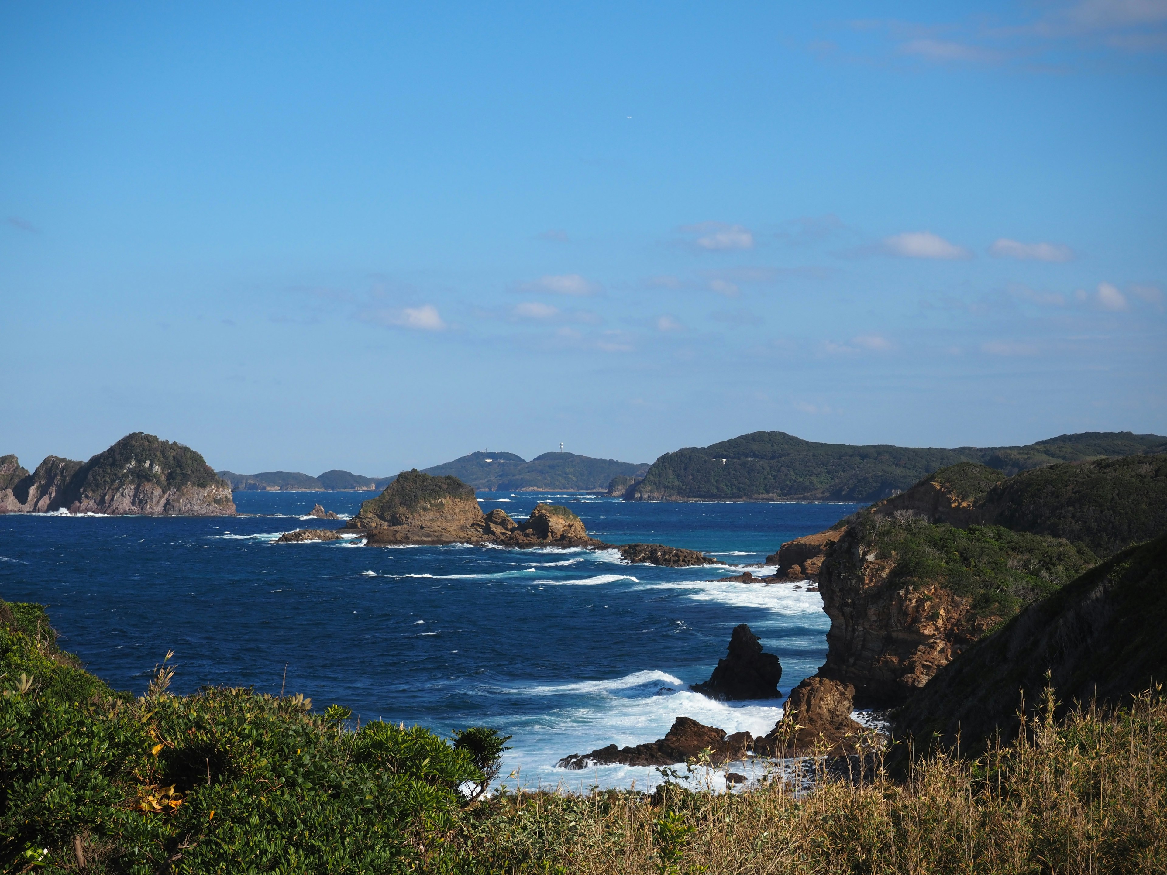 Rocky coastline surrounded by blue ocean and sky