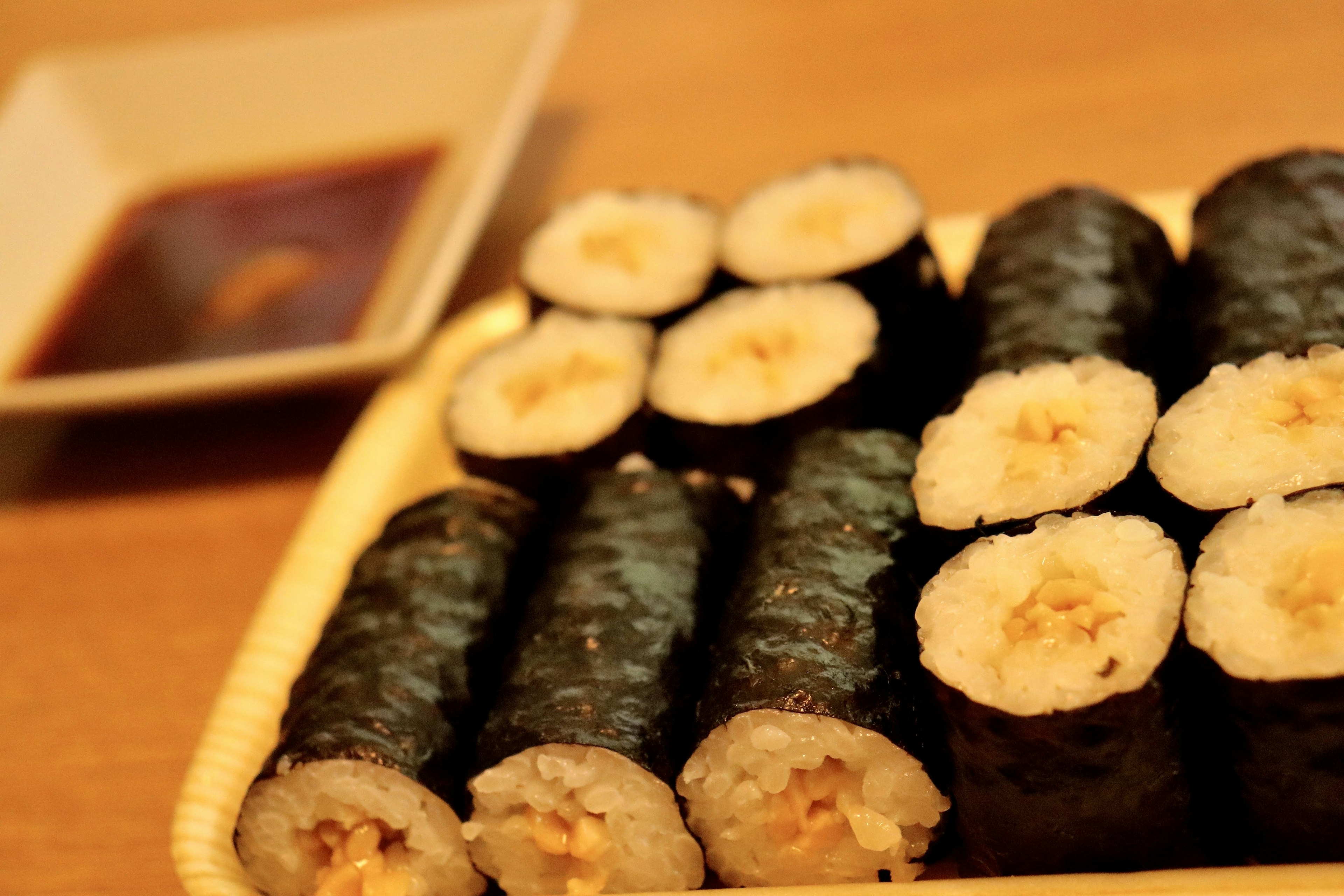 Une assiette de rouleaux de sushi avec une variété de garnitures sur une table en bois