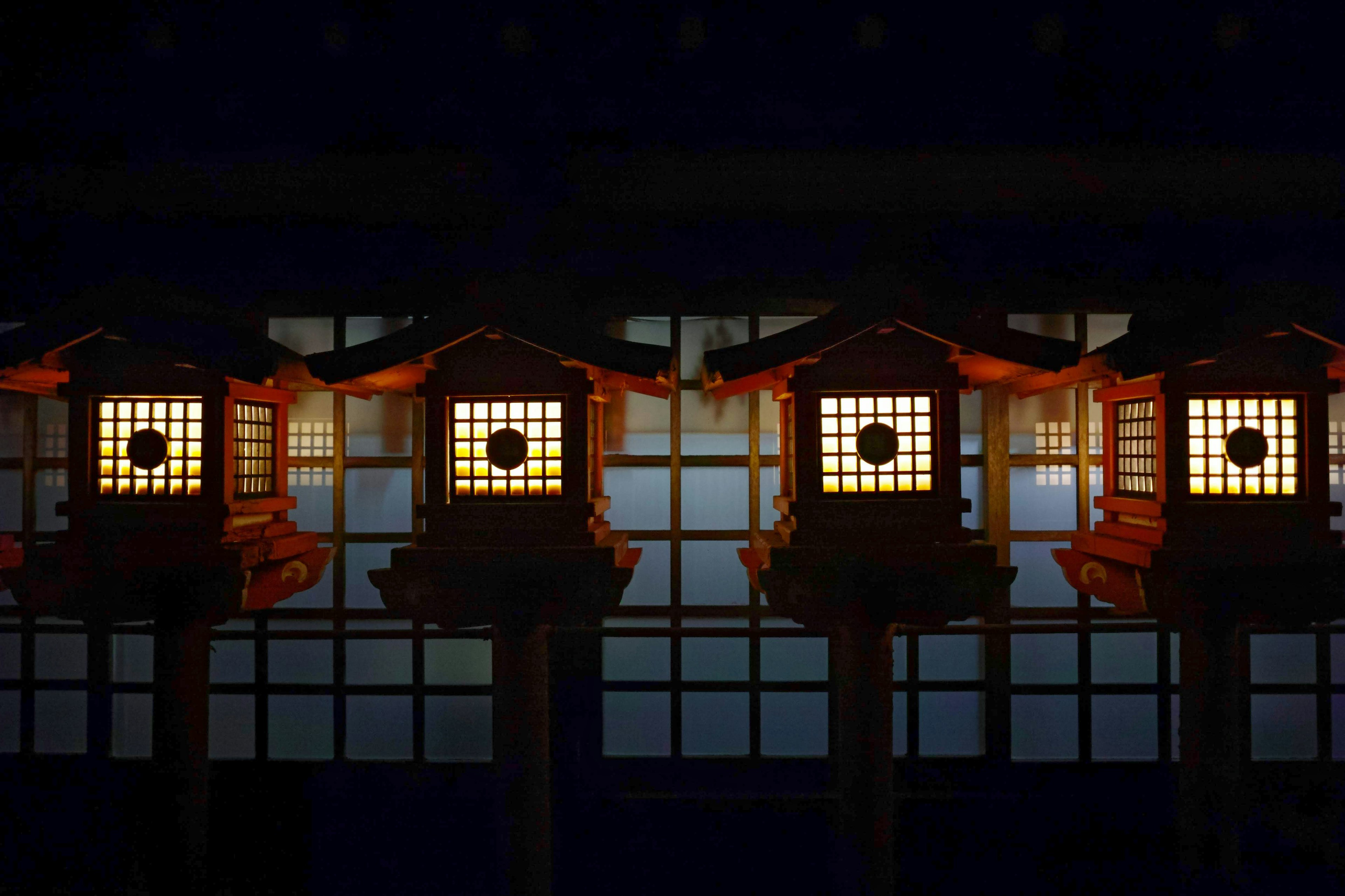 Row of illuminated lanterns against a dark background