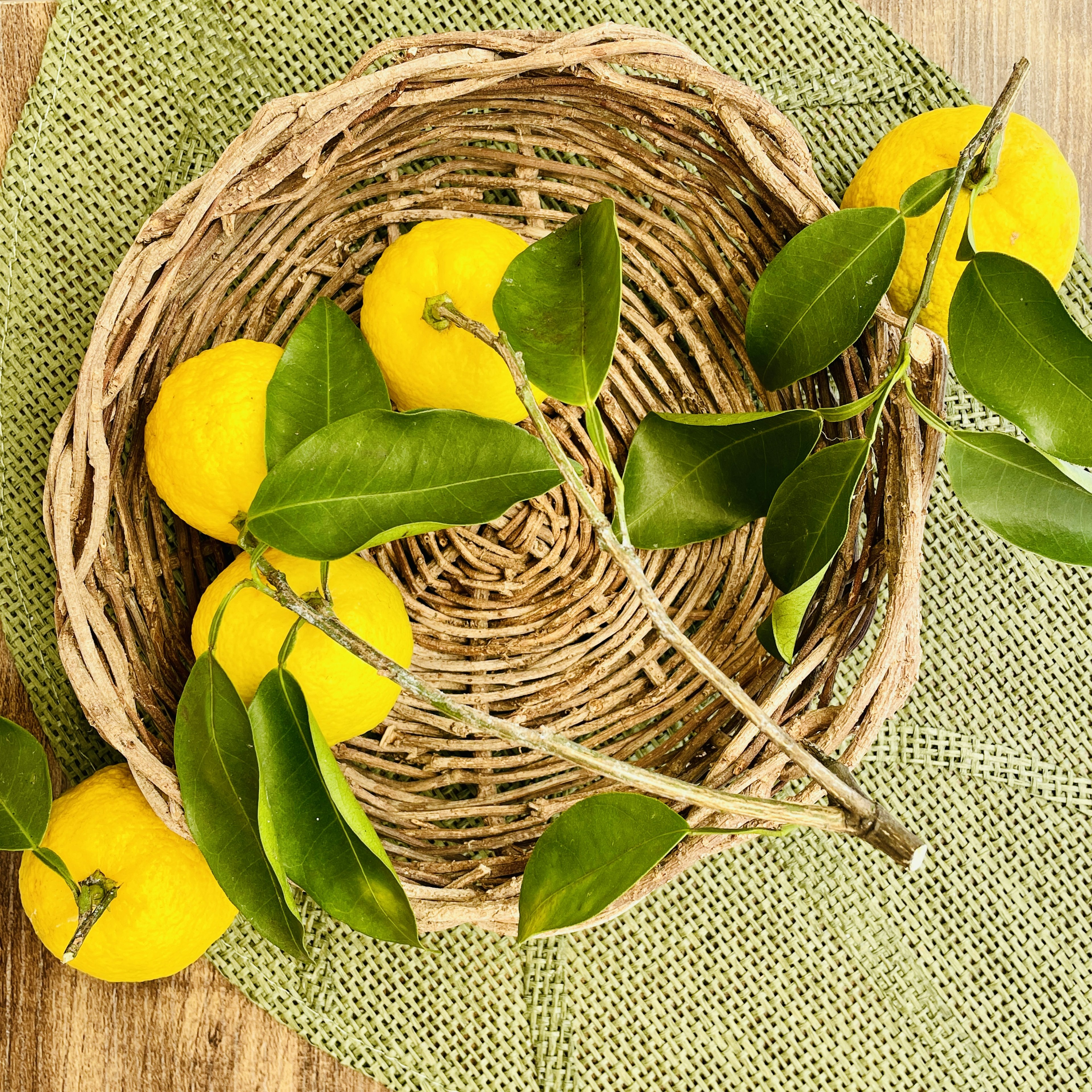 Citrons jaunes et feuilles vertes dans un panier tressé