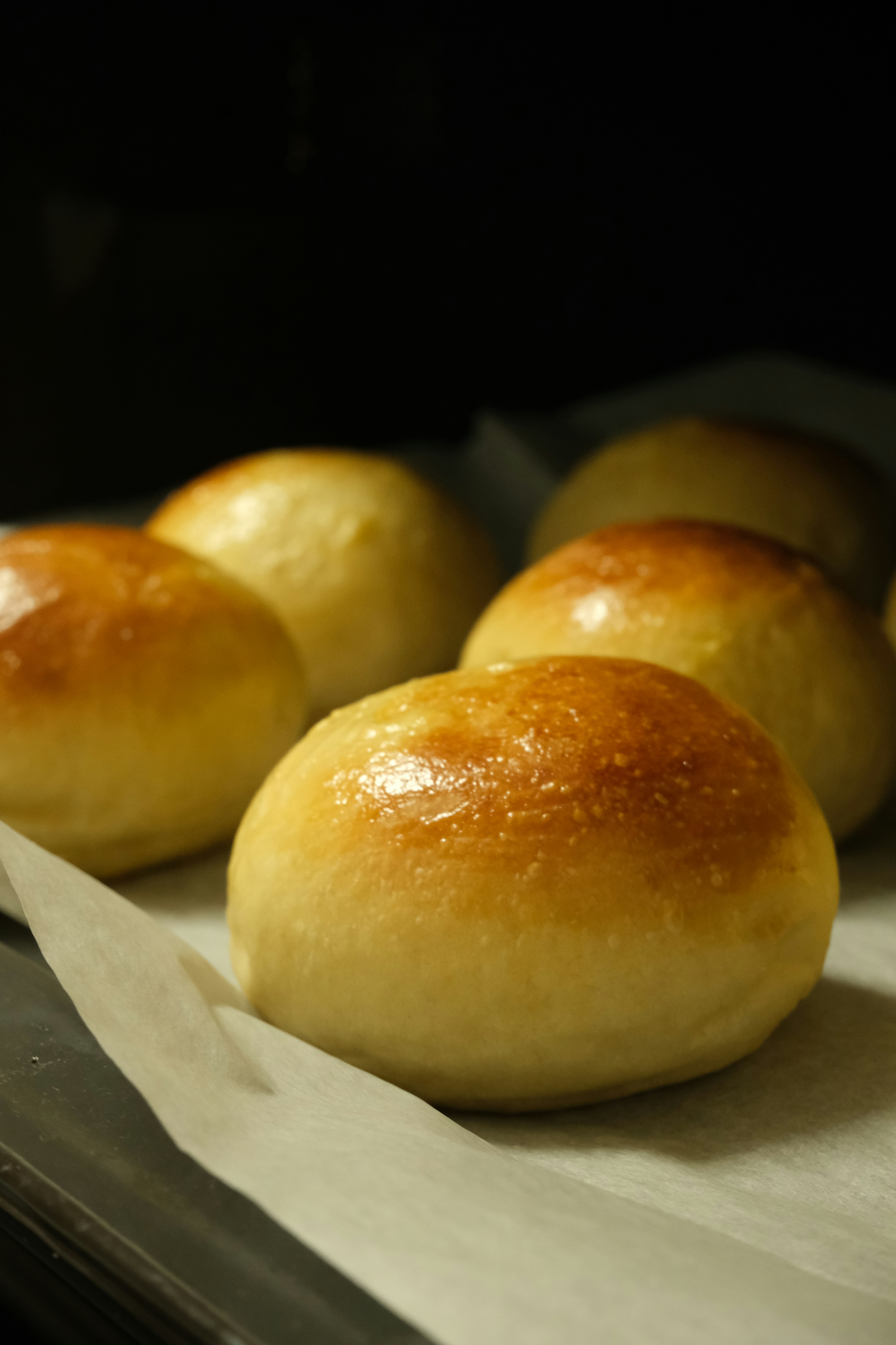 Freshly baked bread rolls arranged on a baking tray