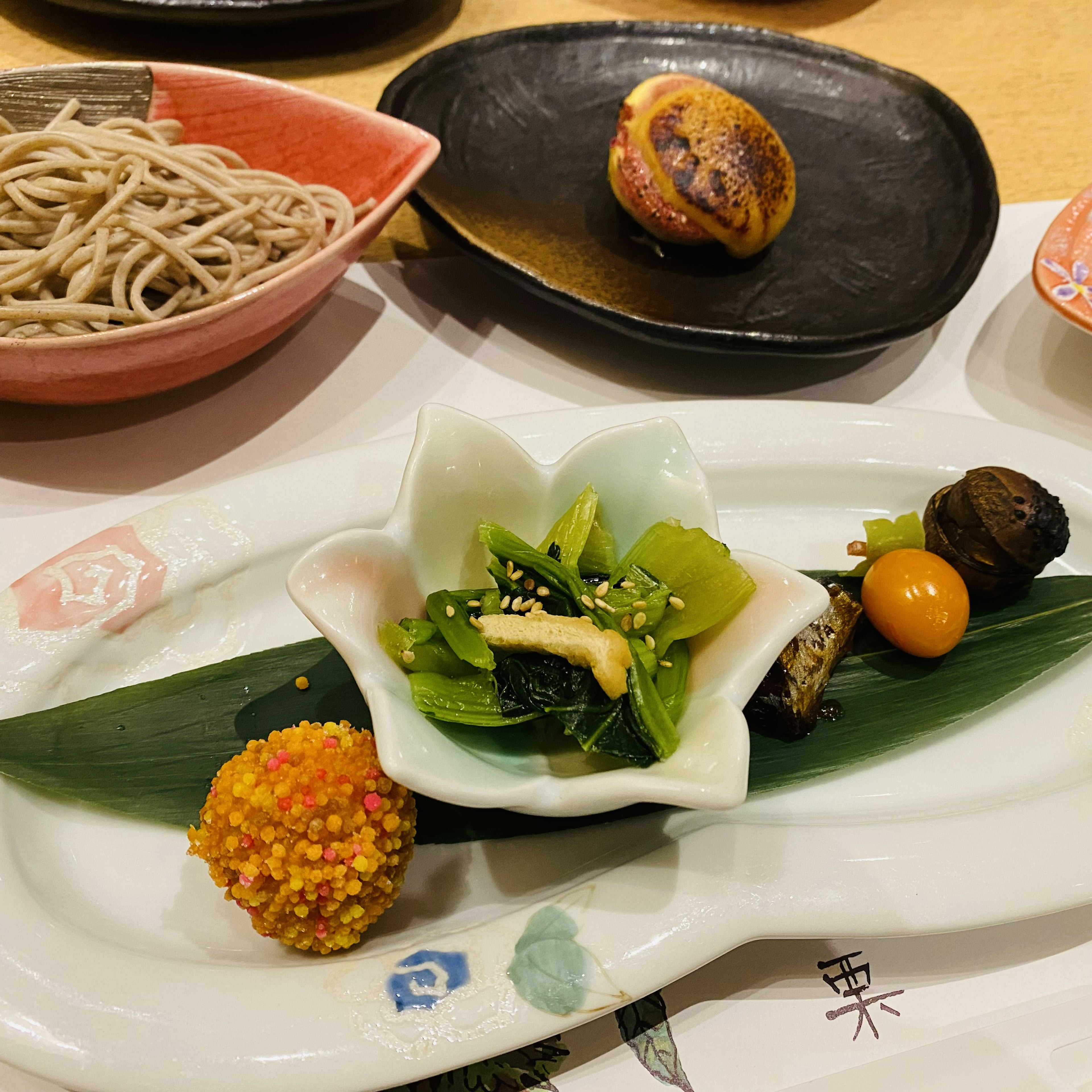 Un plato japonés bellamente presentado con verduras verdes vibrantes e ingredientes coloridos