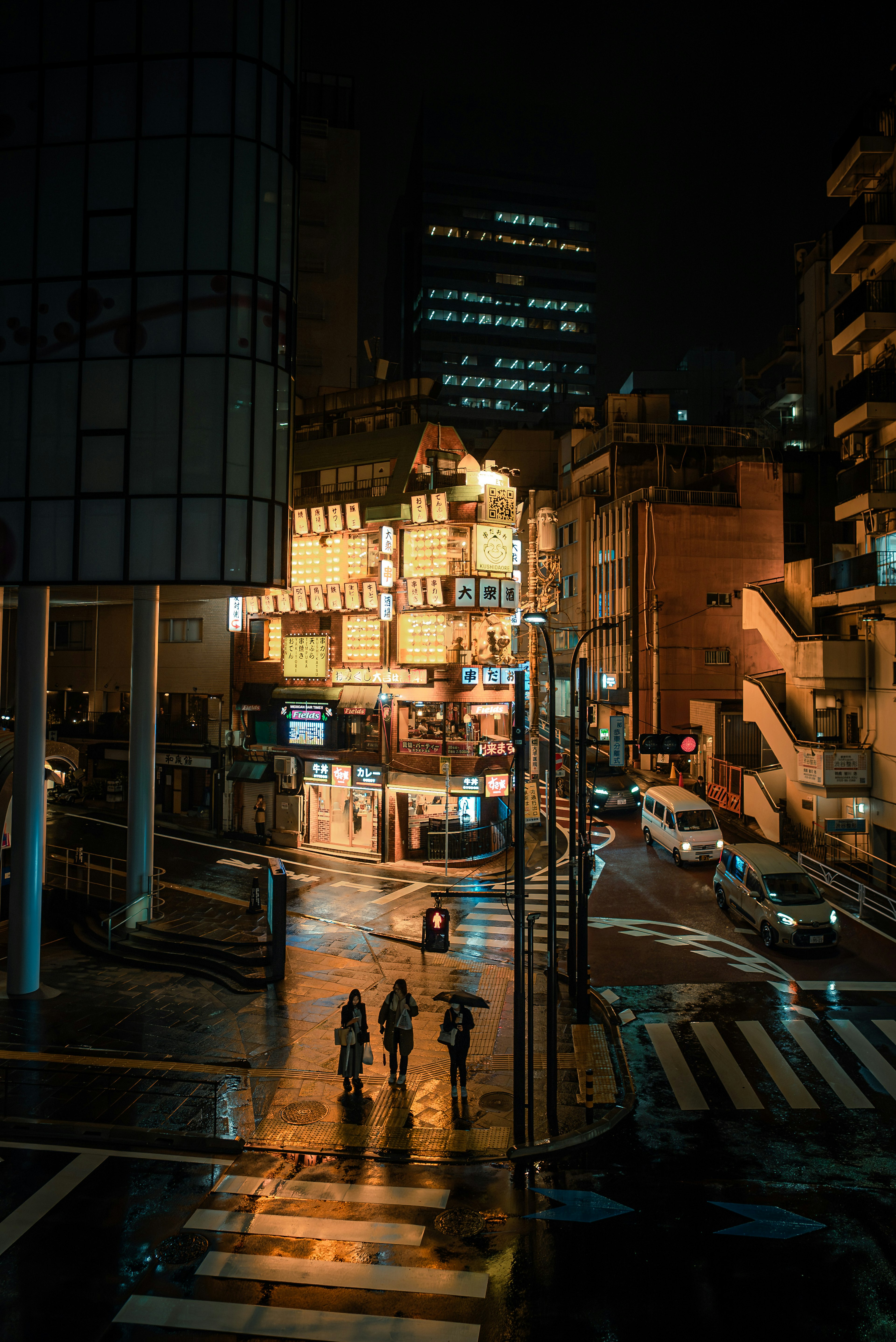 夜の街並みに立つ人々と輝くネオンの看板