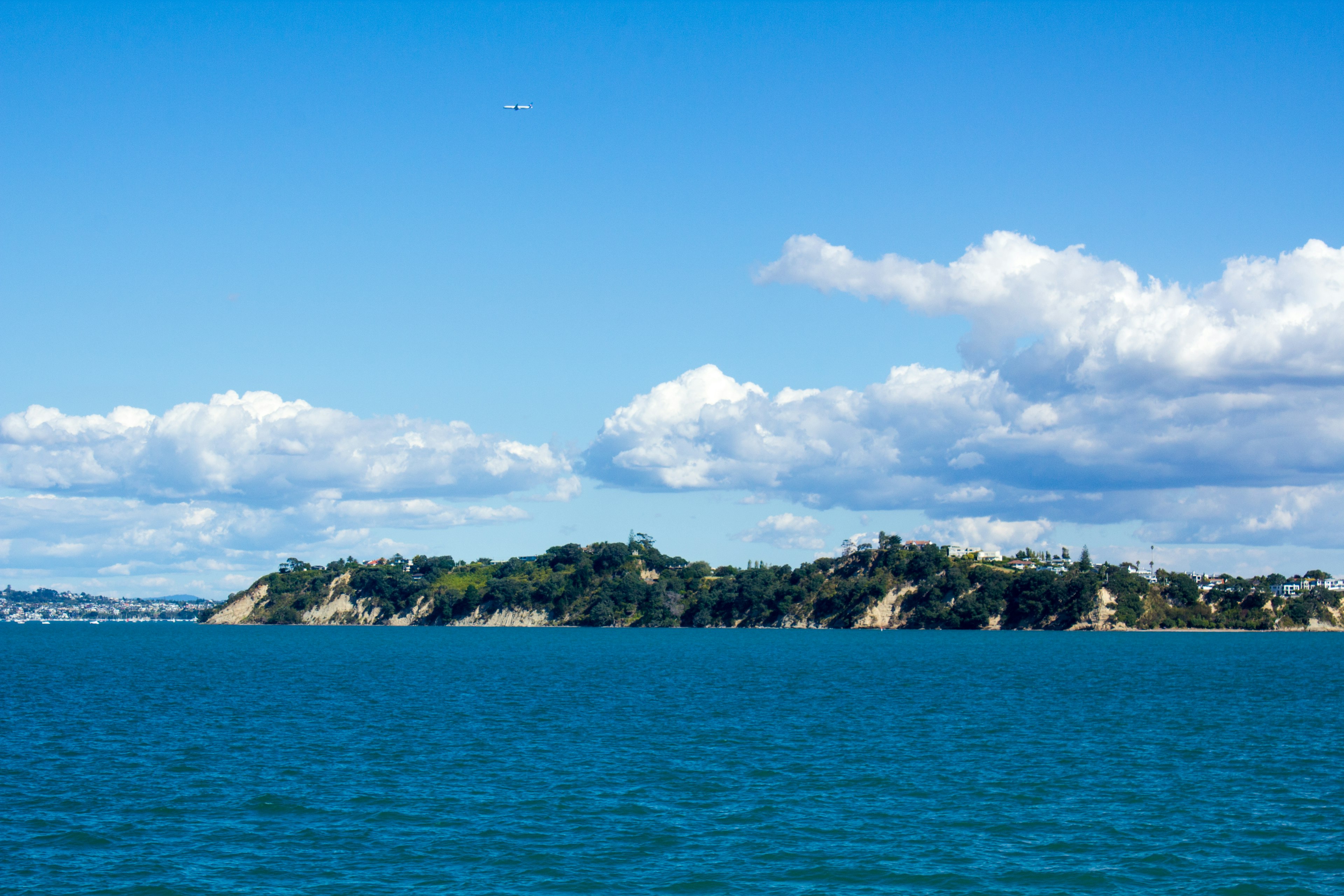 Vue panoramique de l'océan bleu avec des nuages blancs et des collines vertes en arrière-plan