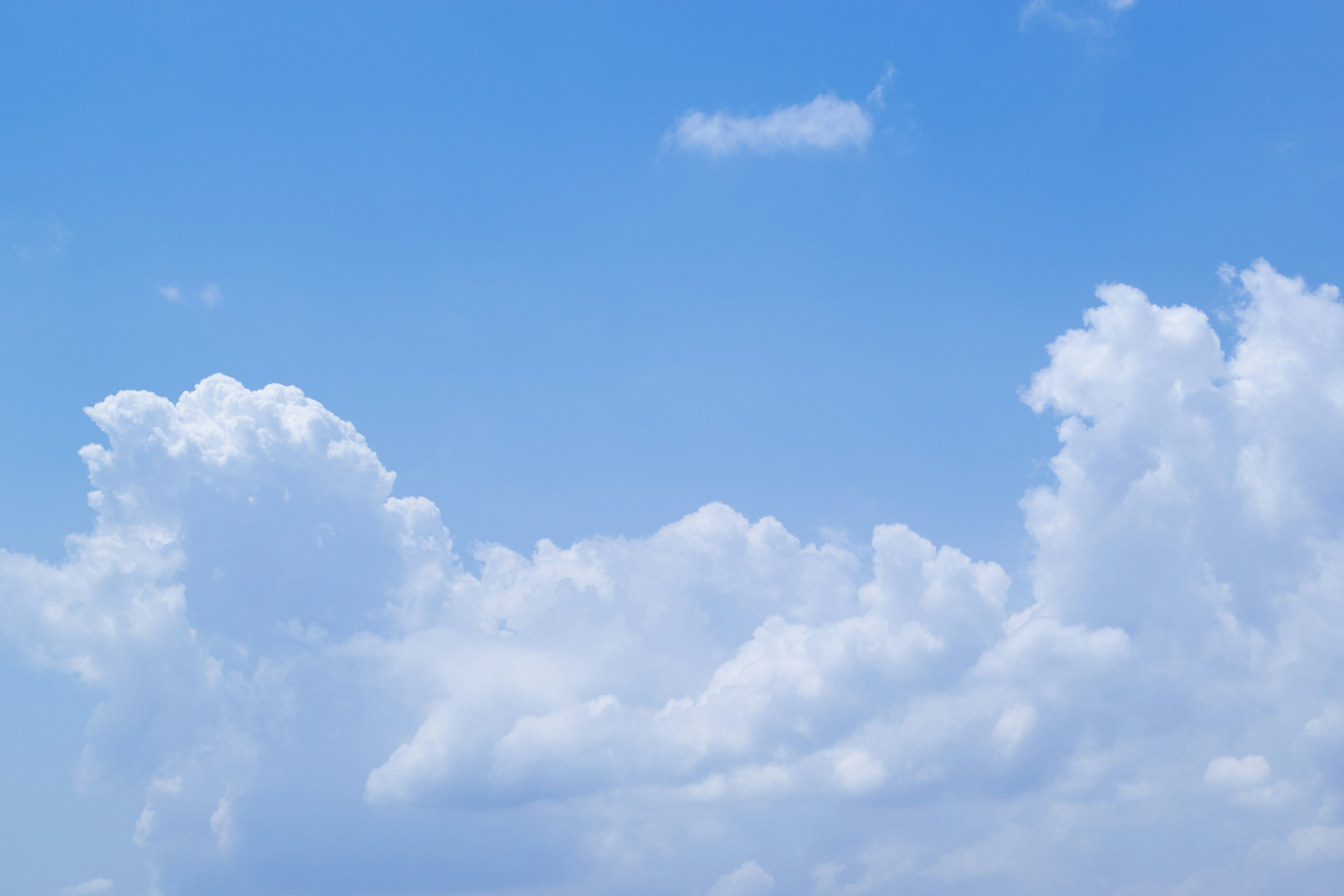 Un paesaggio di nuvole bianche che fluttuano in un cielo blu