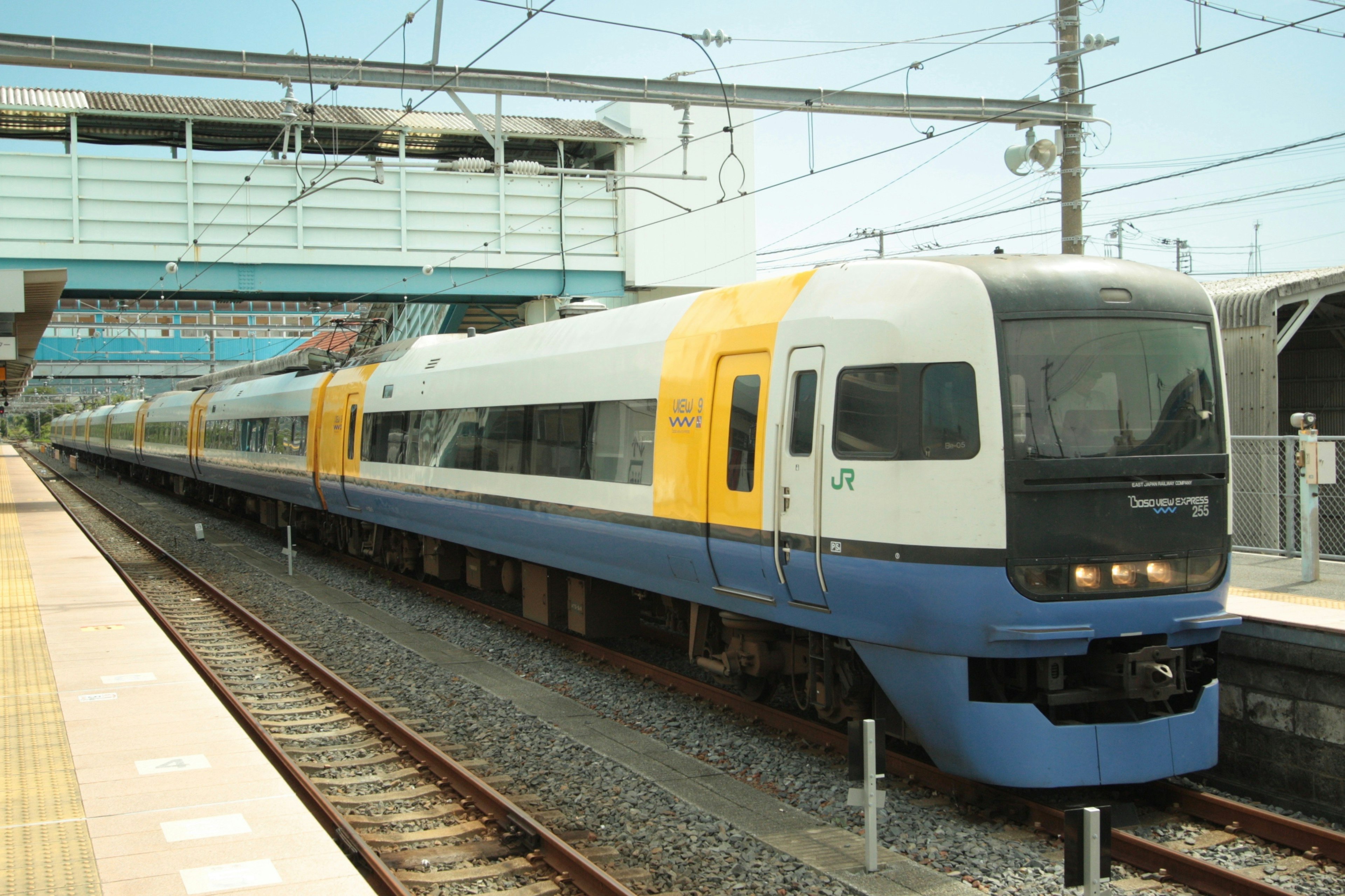 Tren expreso con diseño azul y amarillo detenido en la estación