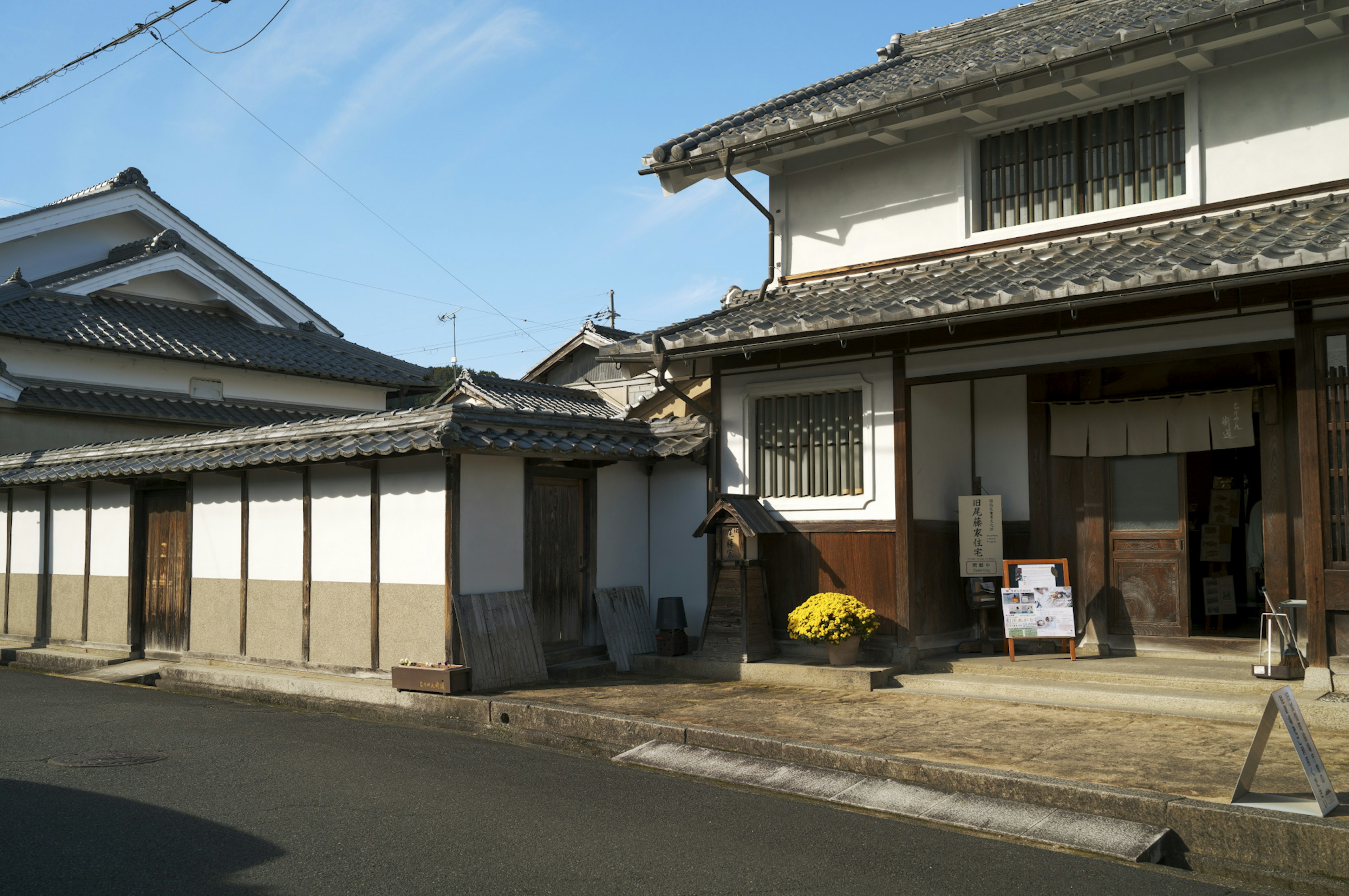 Maison japonaise traditionnelle avec des bâtiments à murs blancs le long de la rue