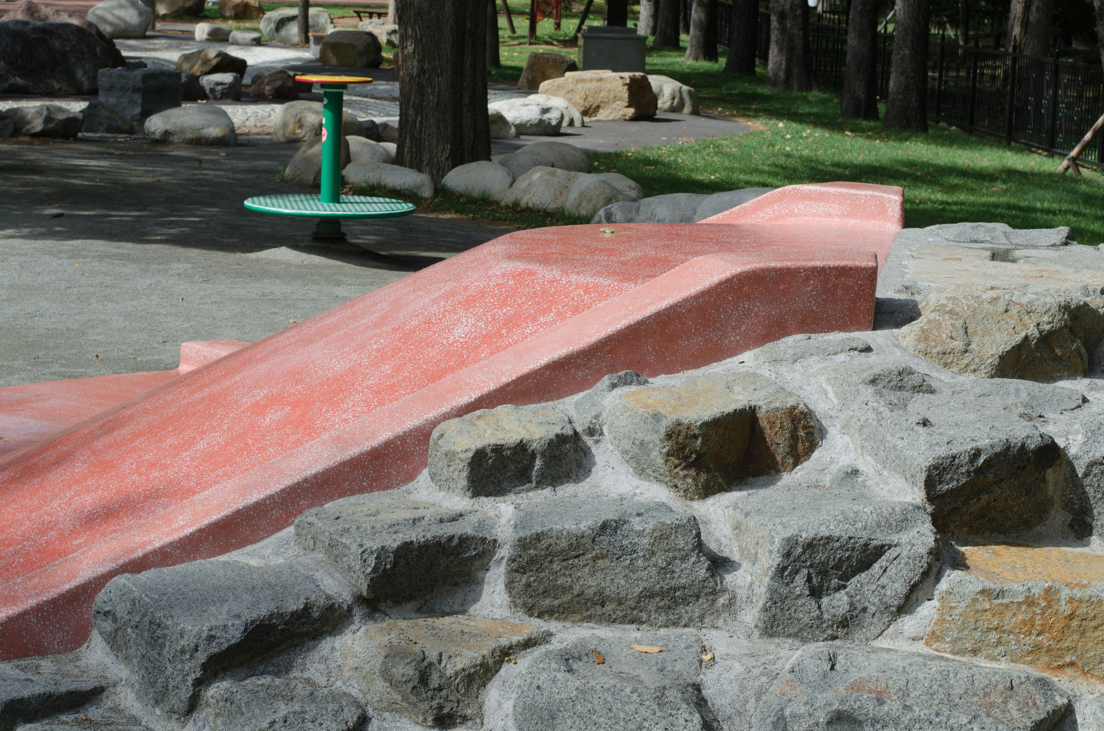 Nahaufnahme einer Rutsche und einer Steinstruktur in einem Park