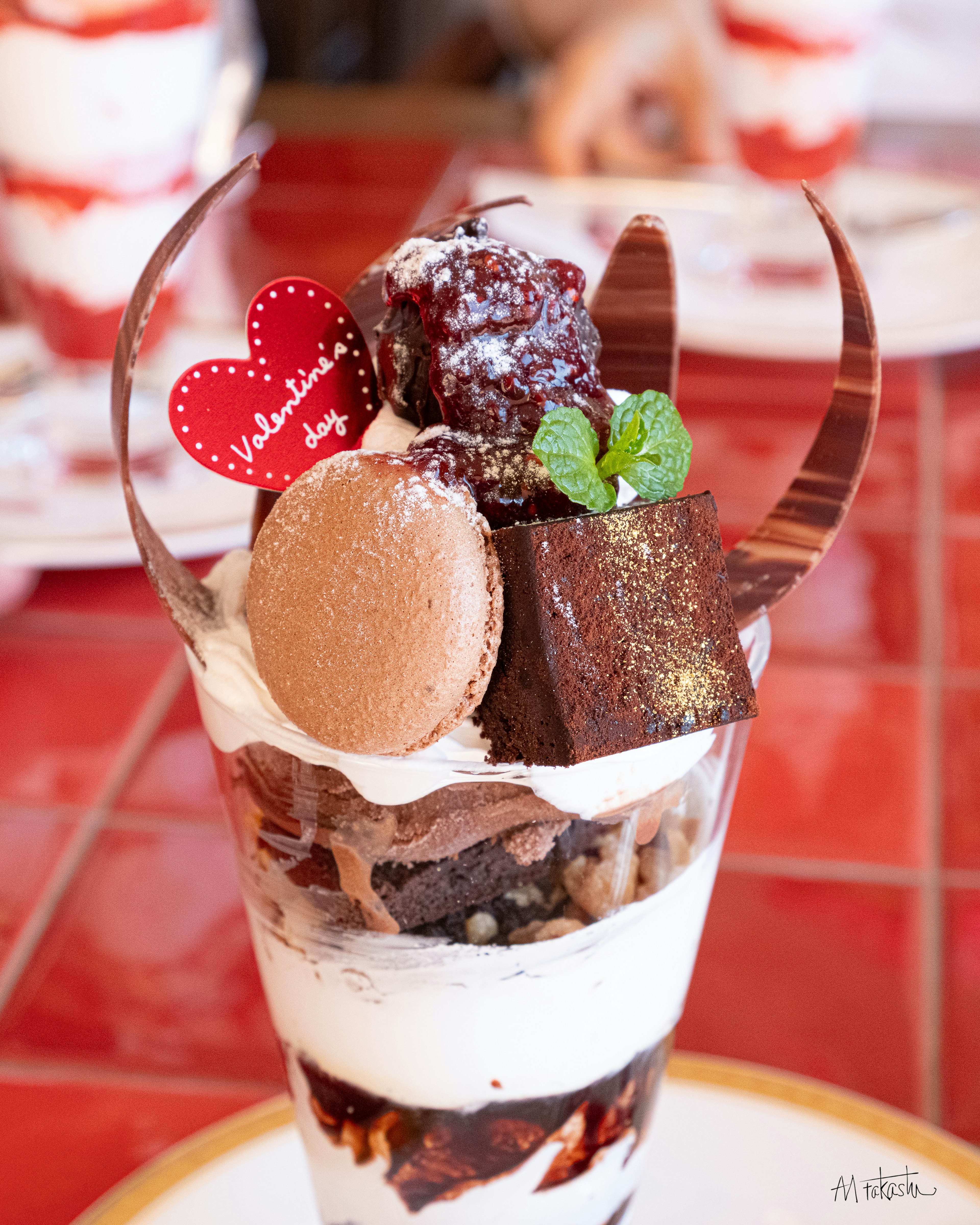 Parfait de postre para San Valentín con chocolate, macarons, hojas de menta y un topping en forma de corazón rojo