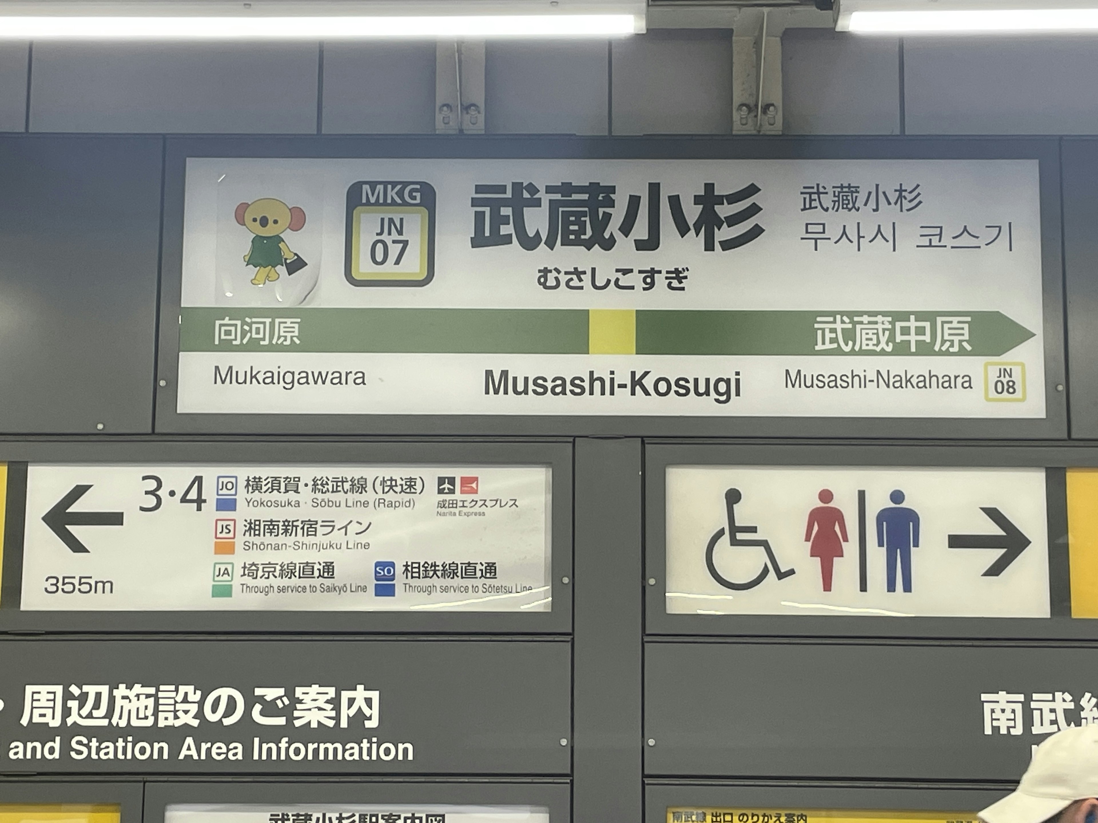 Segnaletica alla stazione Musashi-Kosugi che mostra informazioni sui treni e icone dei bagni