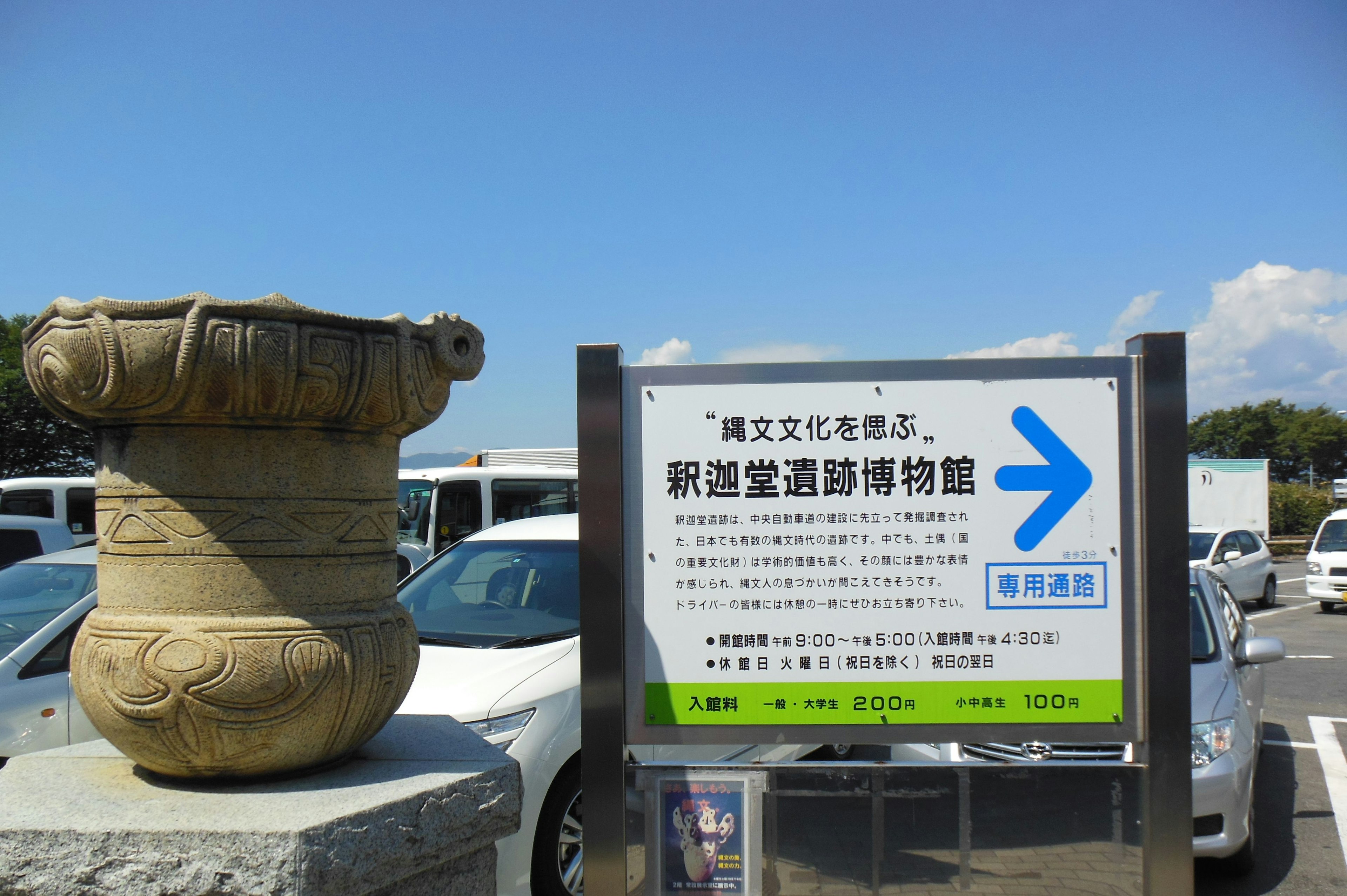 Scene featuring a sign for a cultural heritage museum and an ancient pot