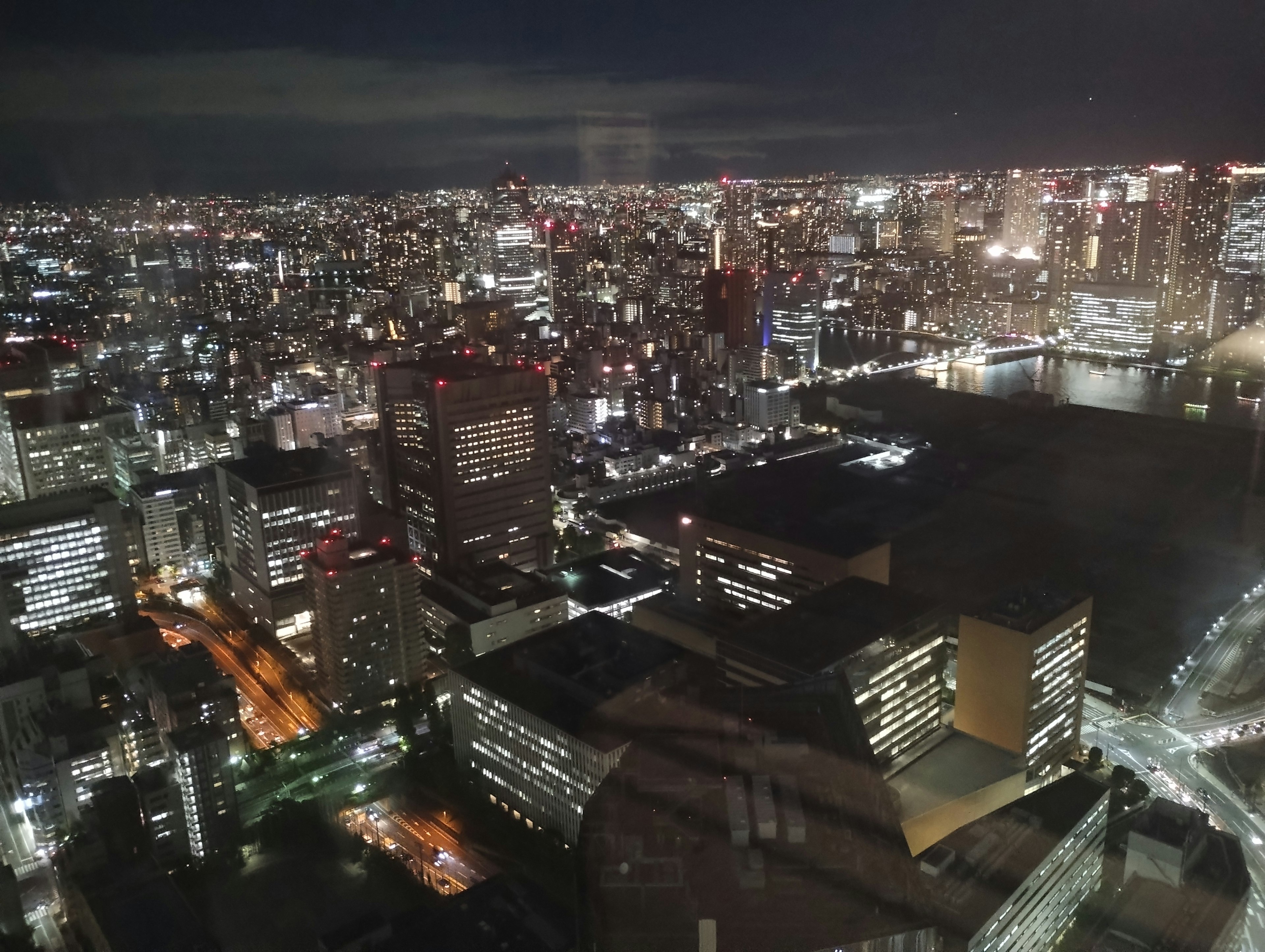 夜间城市天际线的全景视图，特色是照亮的建筑和街灯