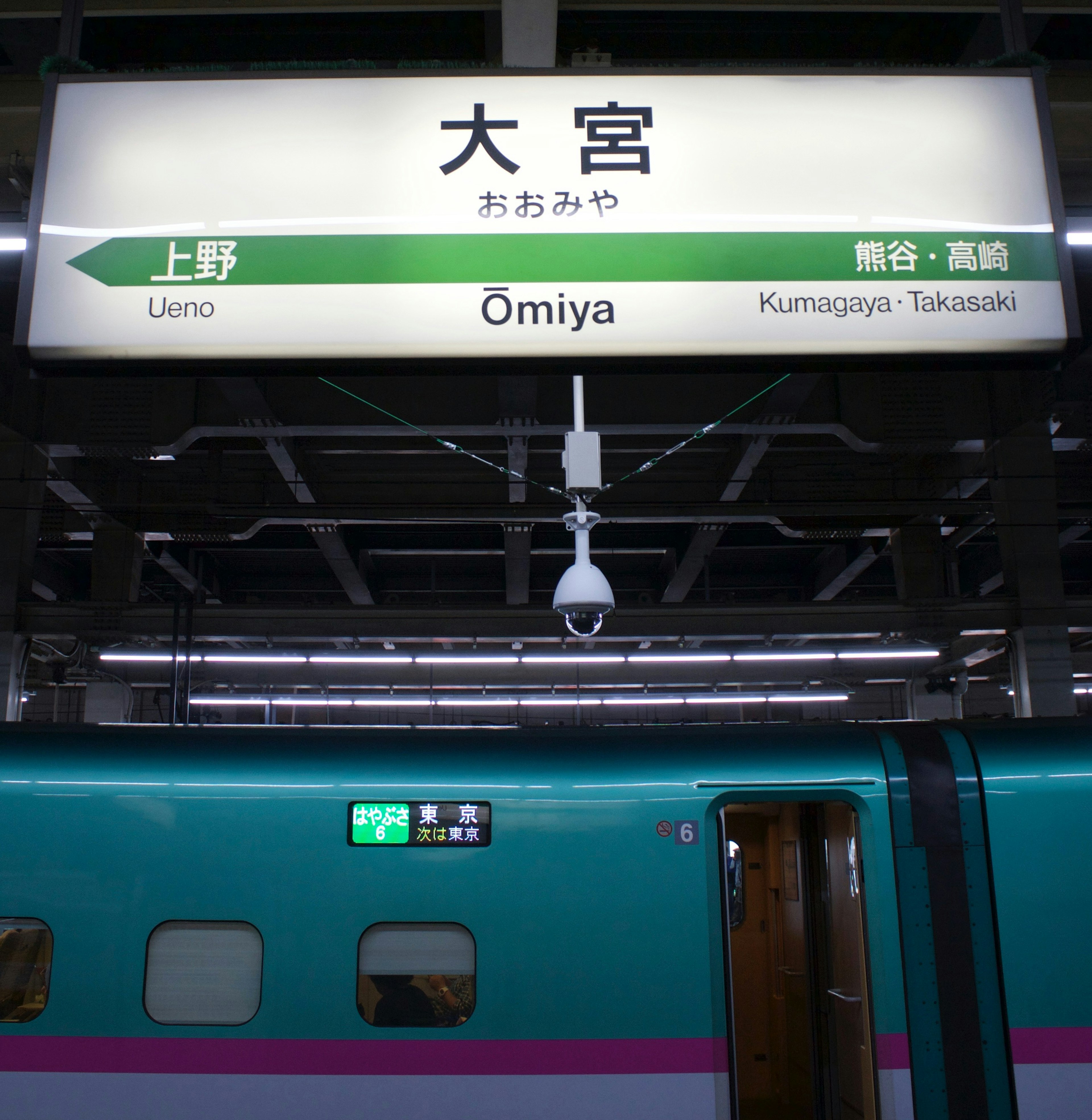 大宮駅の看板と緑色の列車の側面