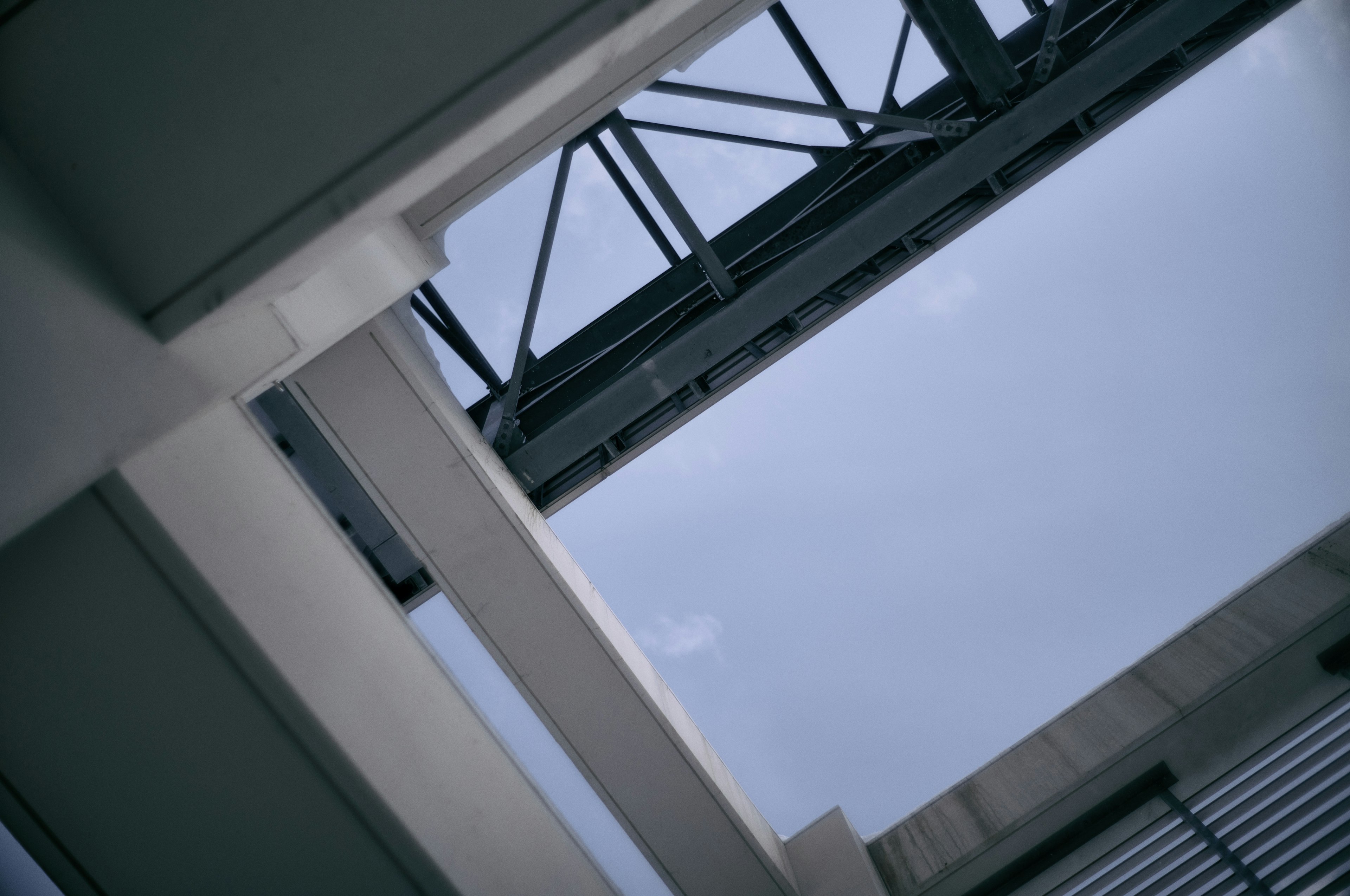 Vue du ciel bleu à travers une structure avec des poutres en acier