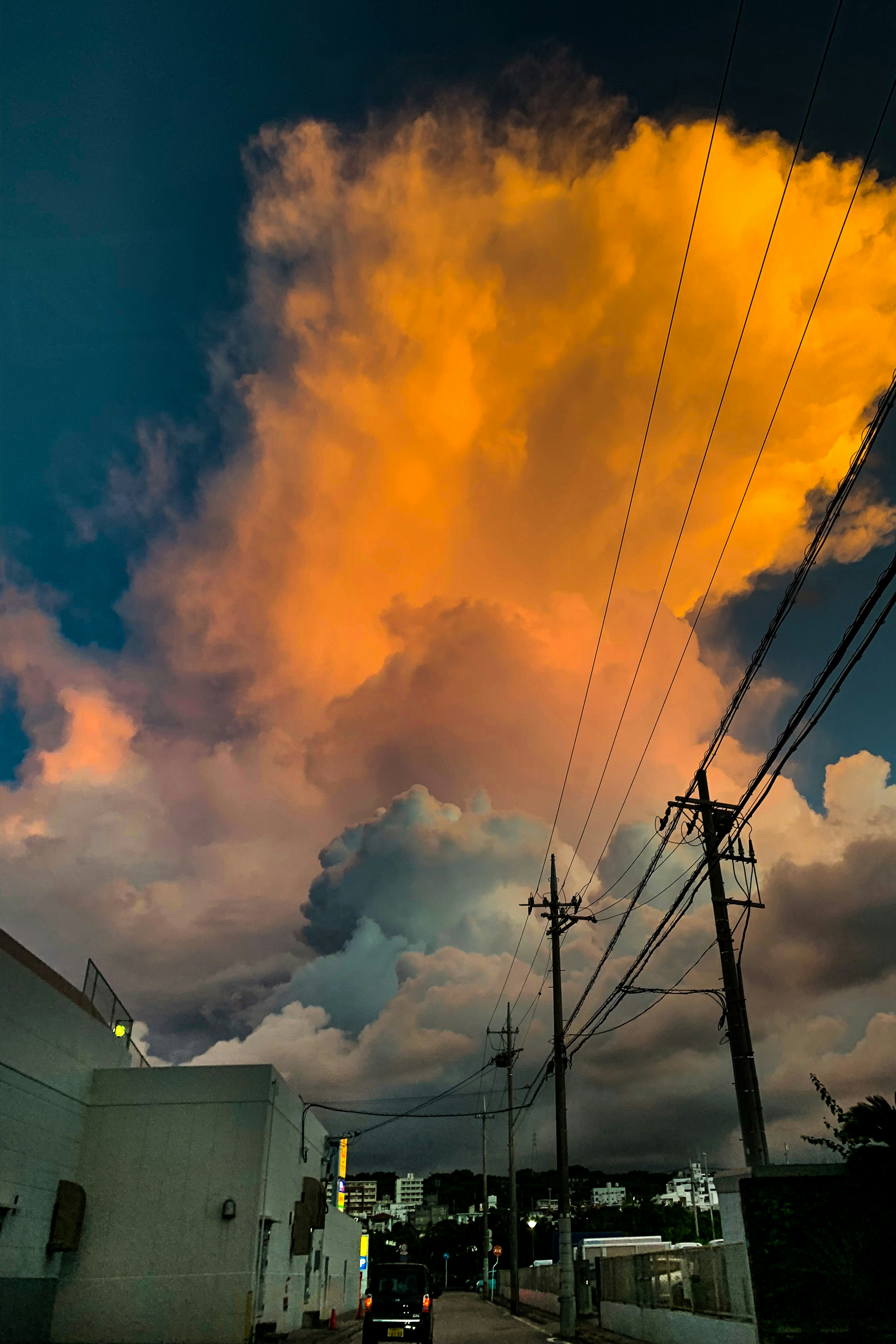 Nubes de atardecer vibrantes iluminadas contra un cielo oscurecido con líneas eléctricas