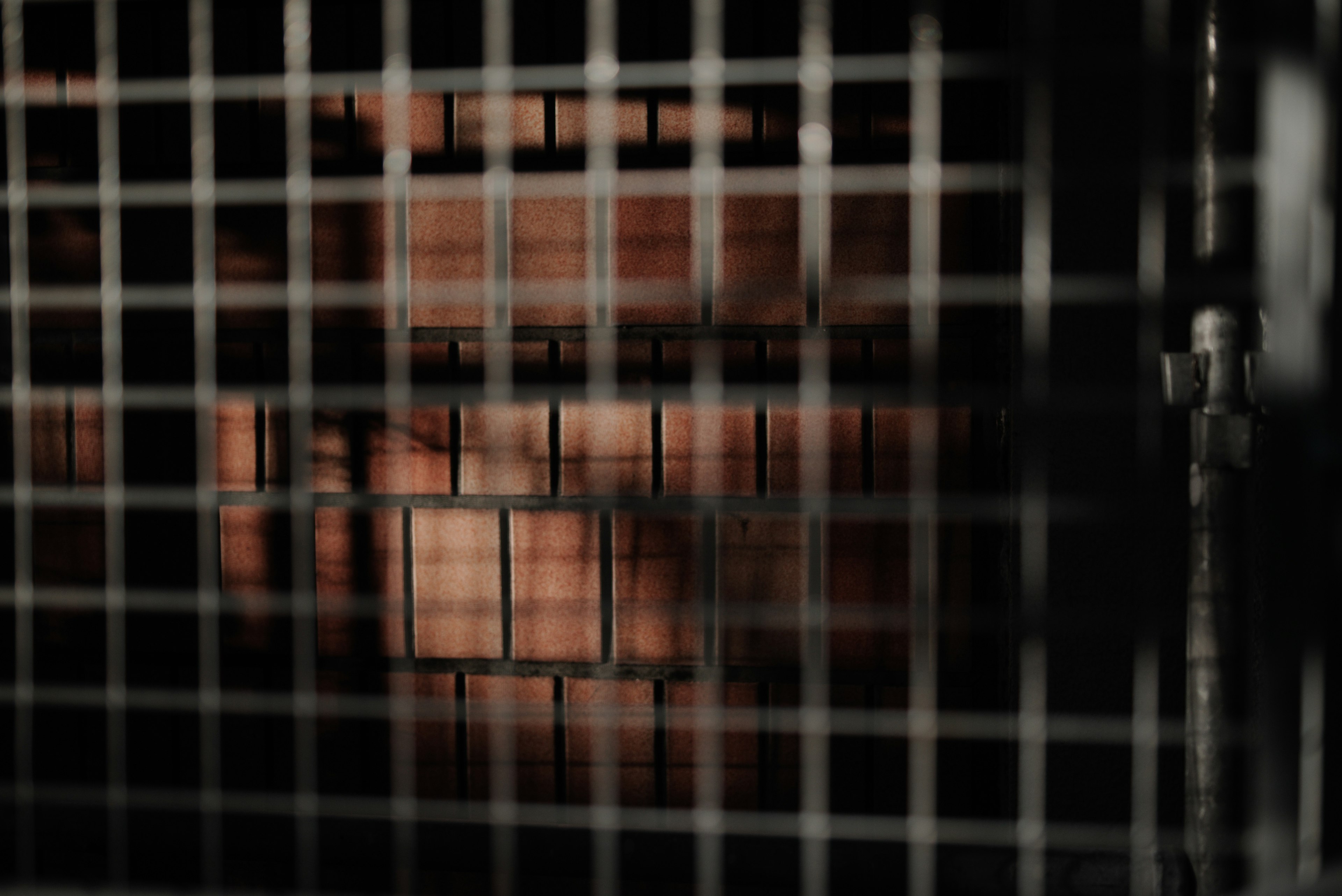 Wooden box and shadow seen through metal grid