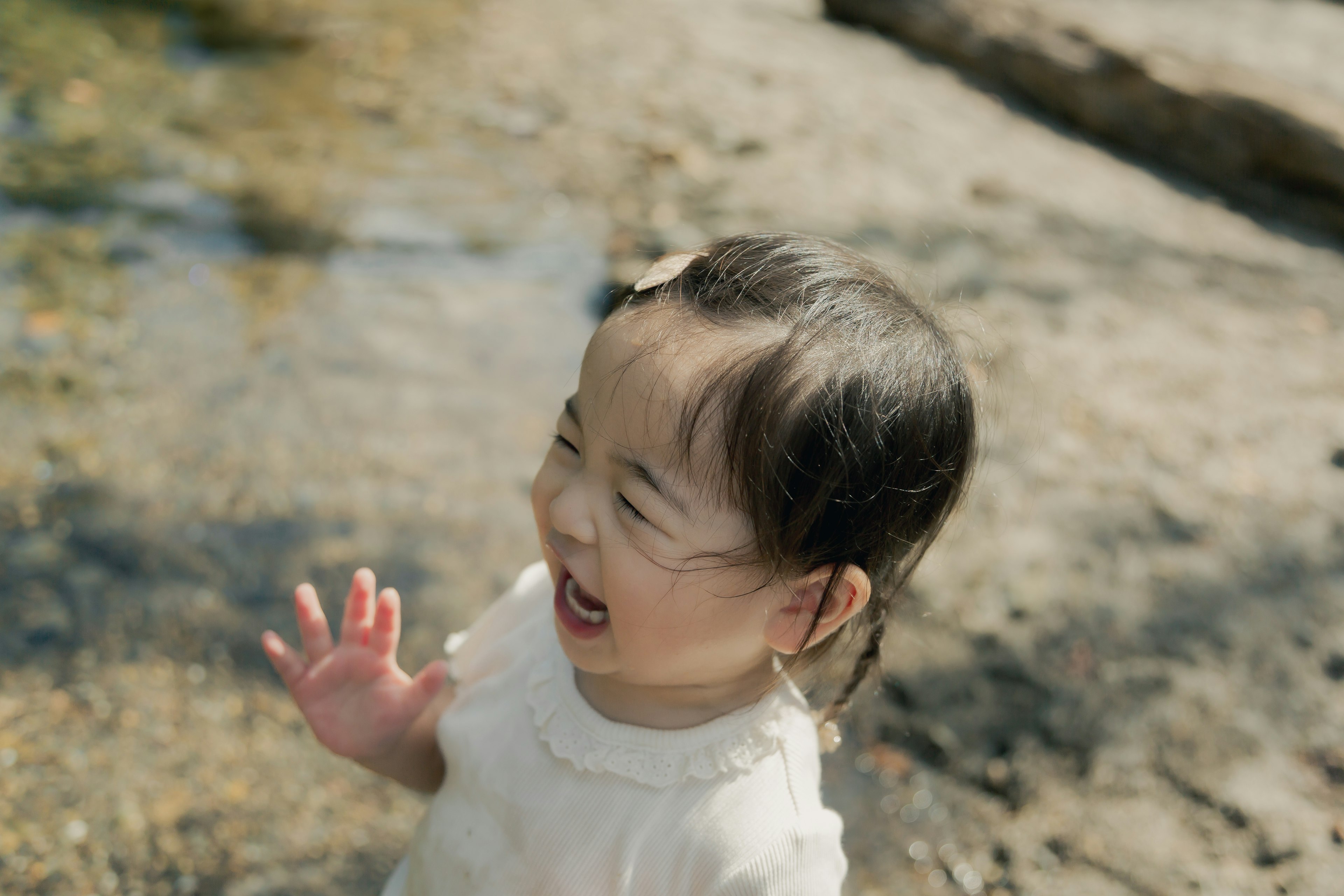 Child playing by the water with a joyful expression