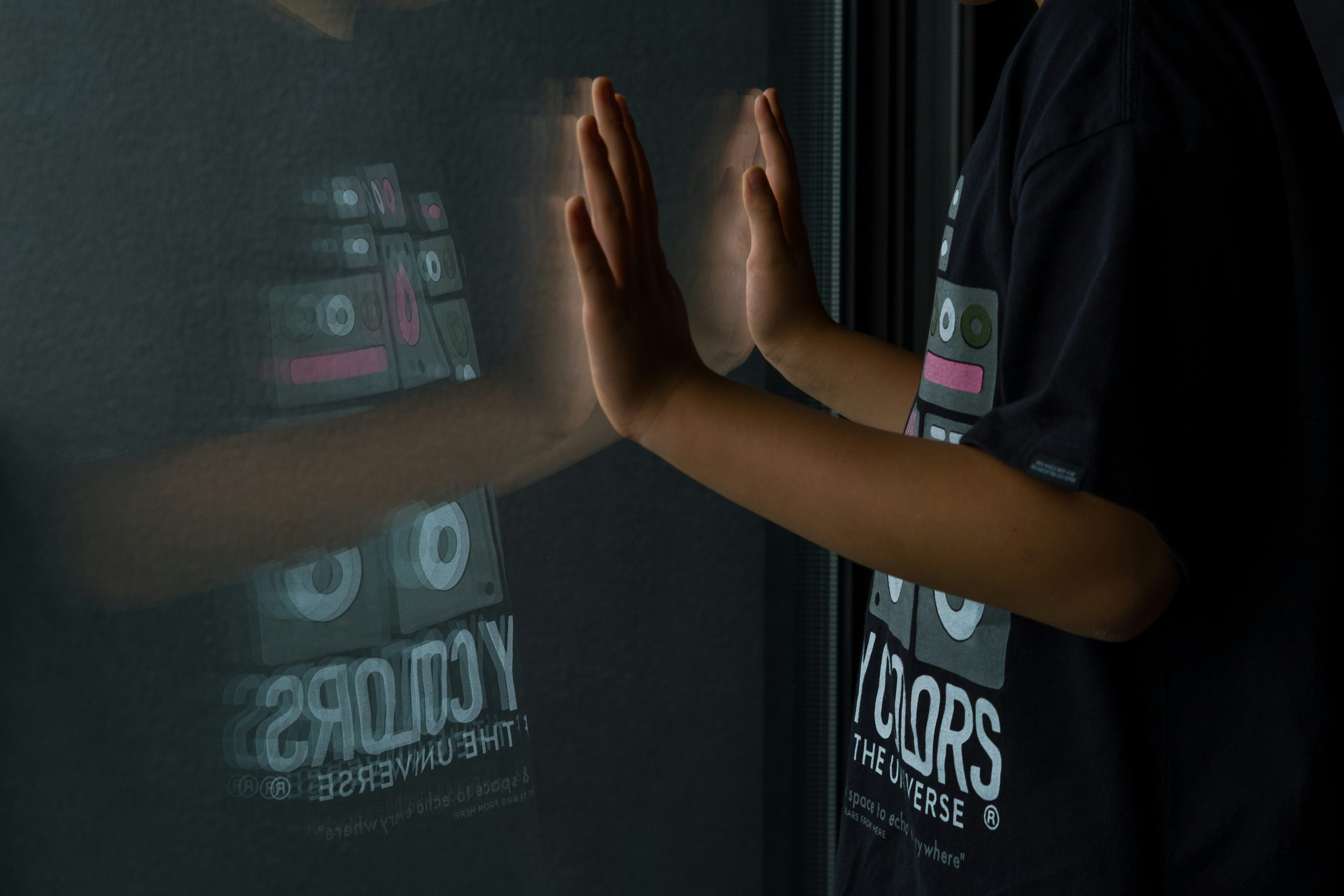 Person with hands on a window reflecting the shirt design