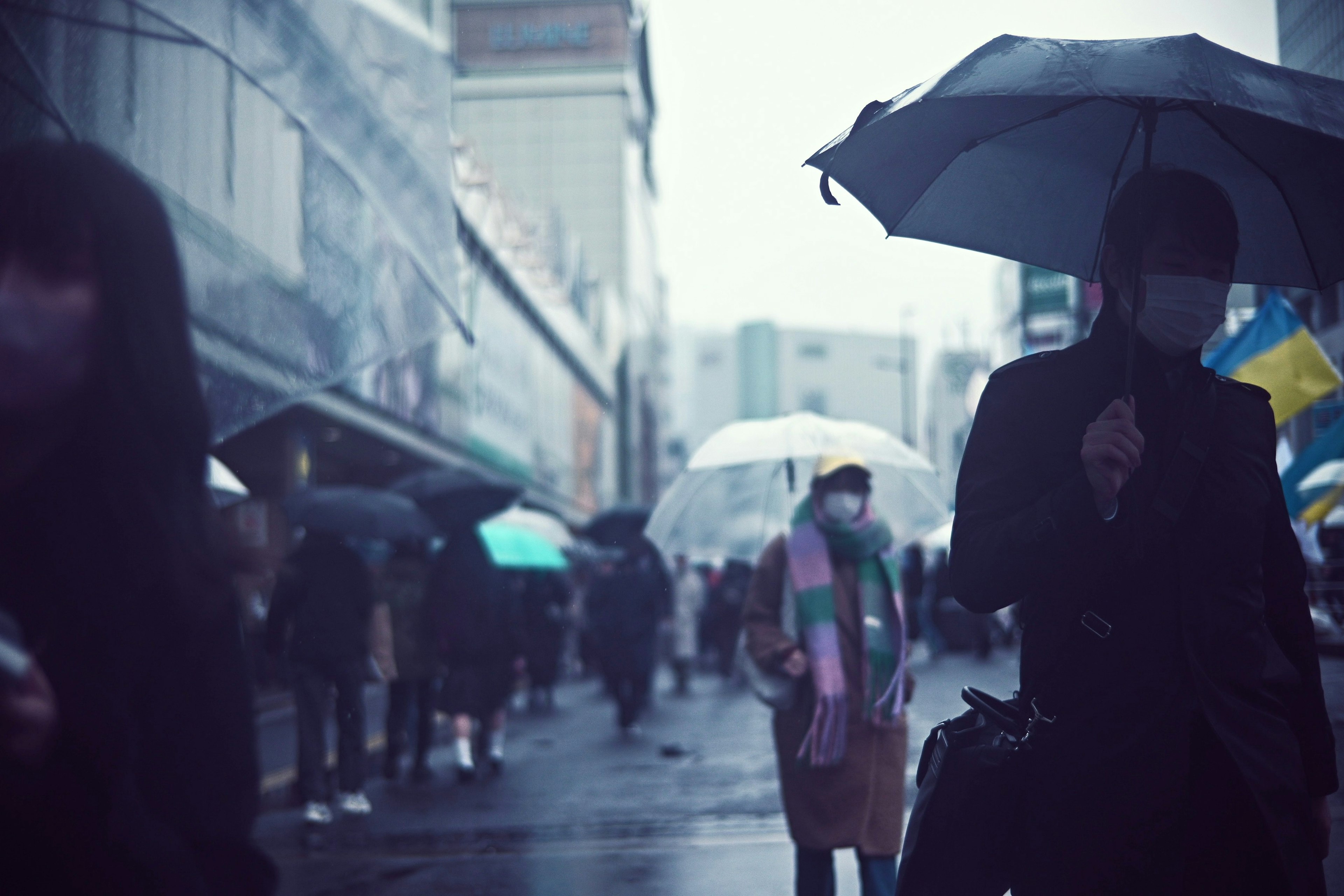 Foule de personnes marchant avec des parapluies sous la pluie et paysage urbain