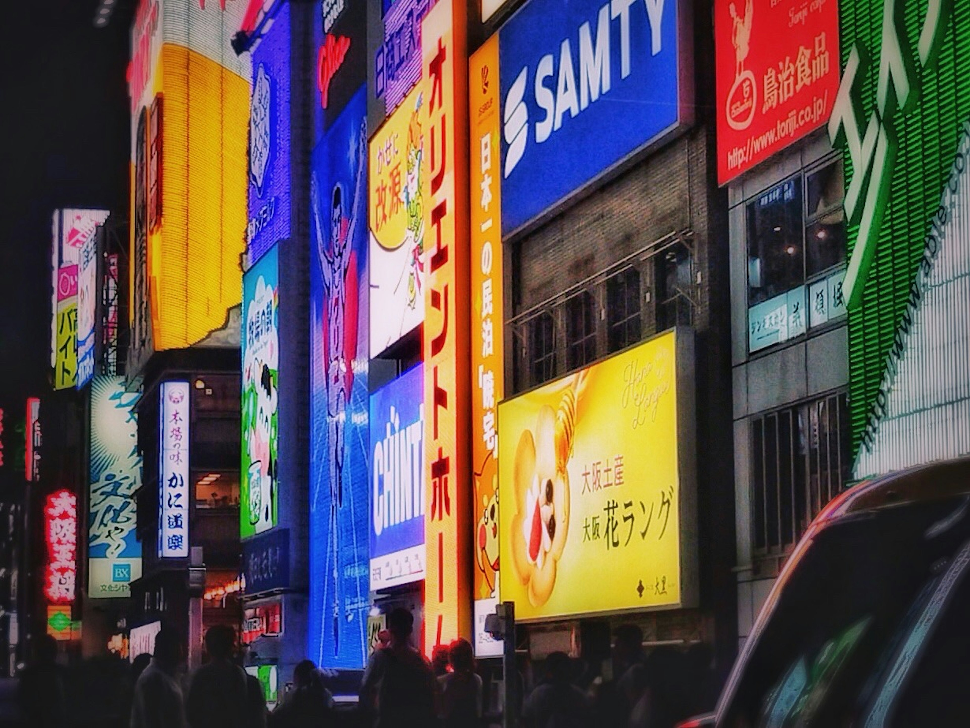 Brillantes letreros de neón y pancartas coloridas en un paisaje urbano nocturno