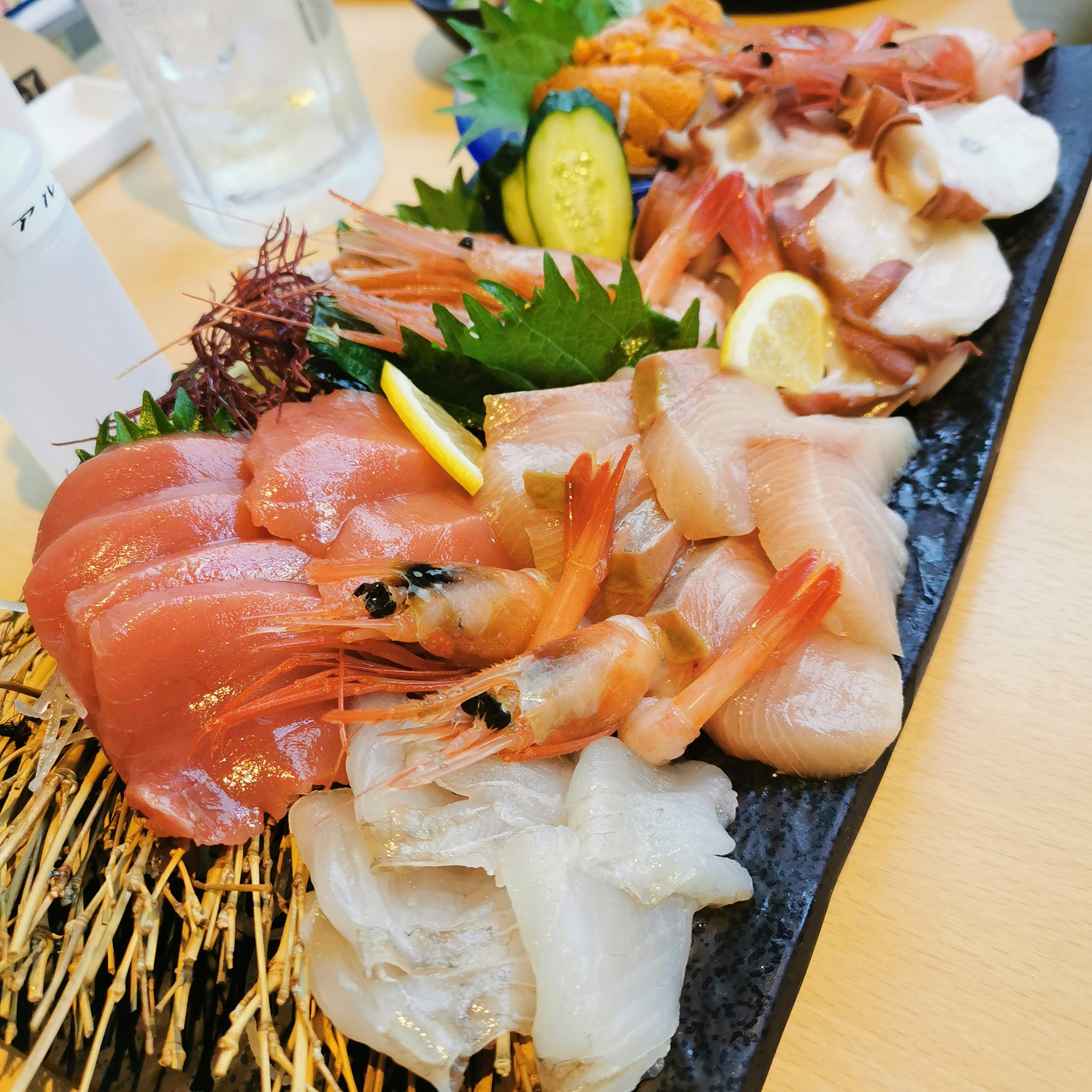 A beautifully arranged platter of fresh sashimi including shrimp and various fish