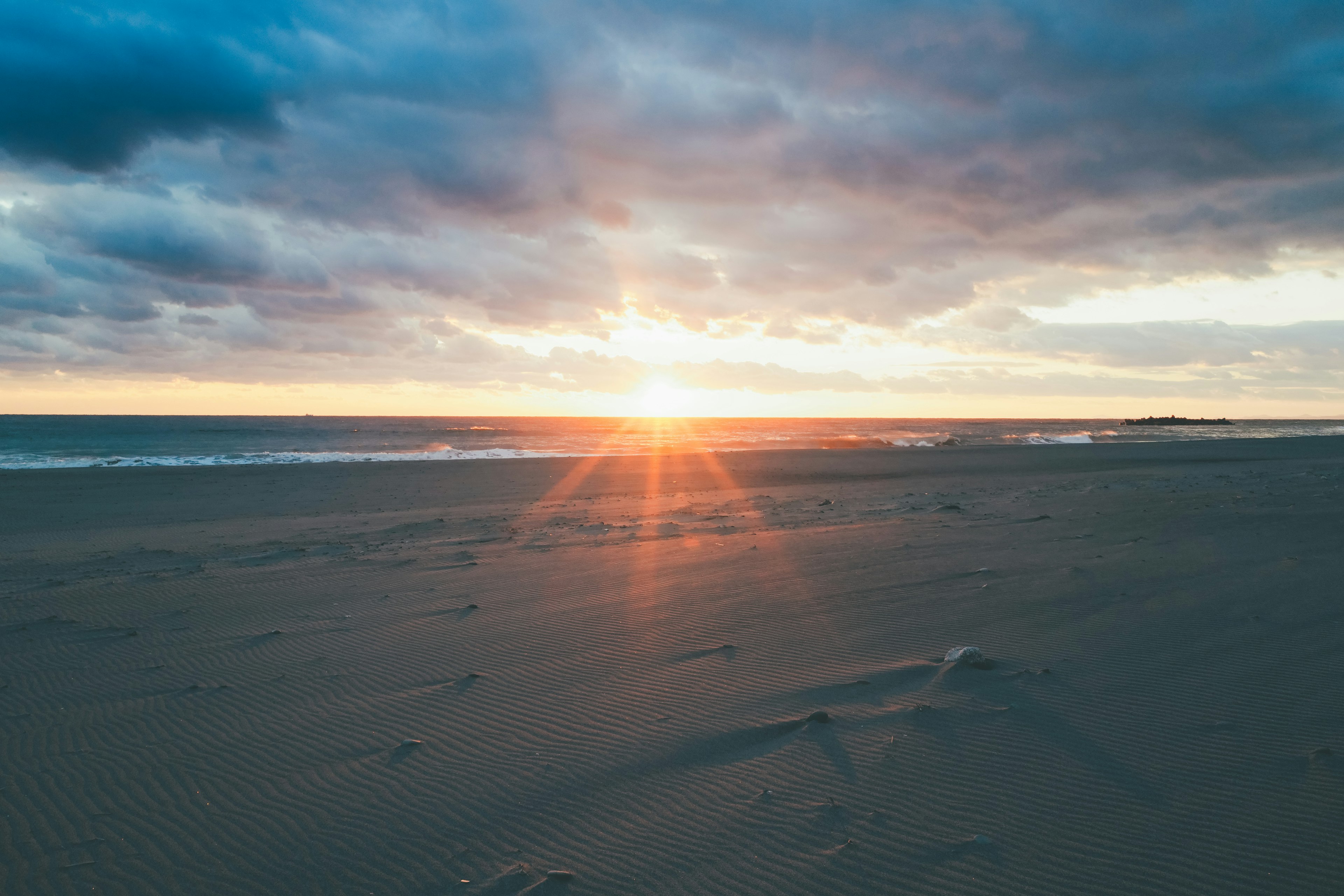 Bellissimo tramonto sull'oceano con impronte sulla spiaggia di sabbia