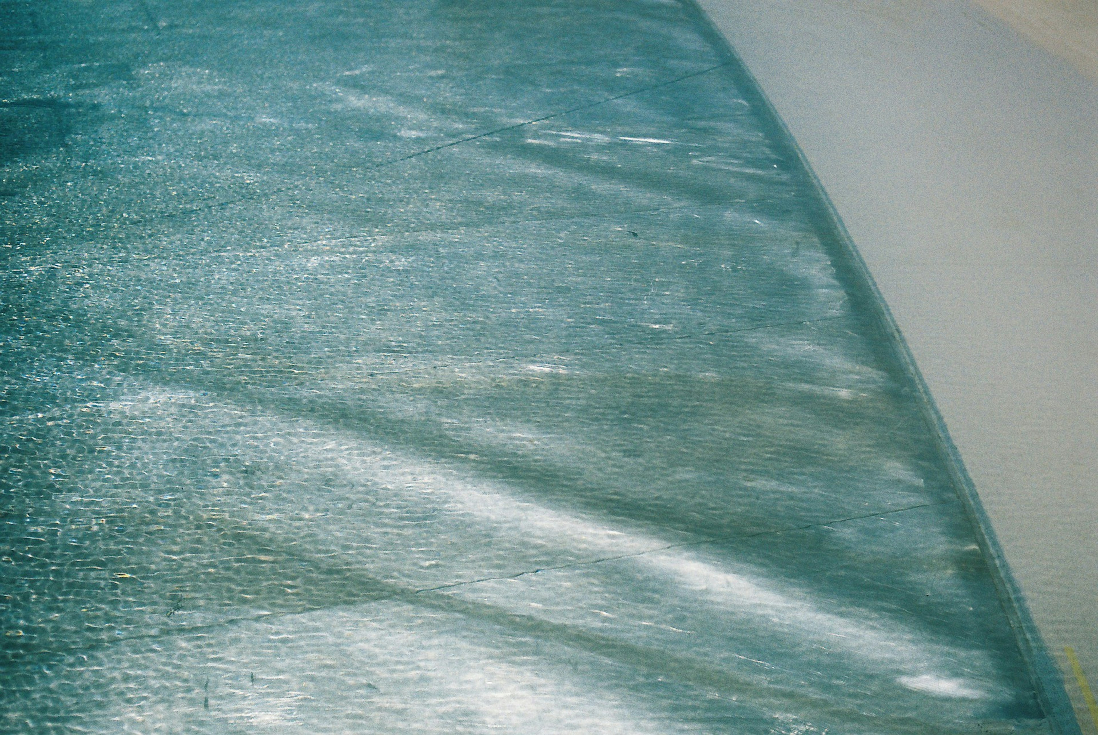 Close-up of blue water surface meeting white sandy beach