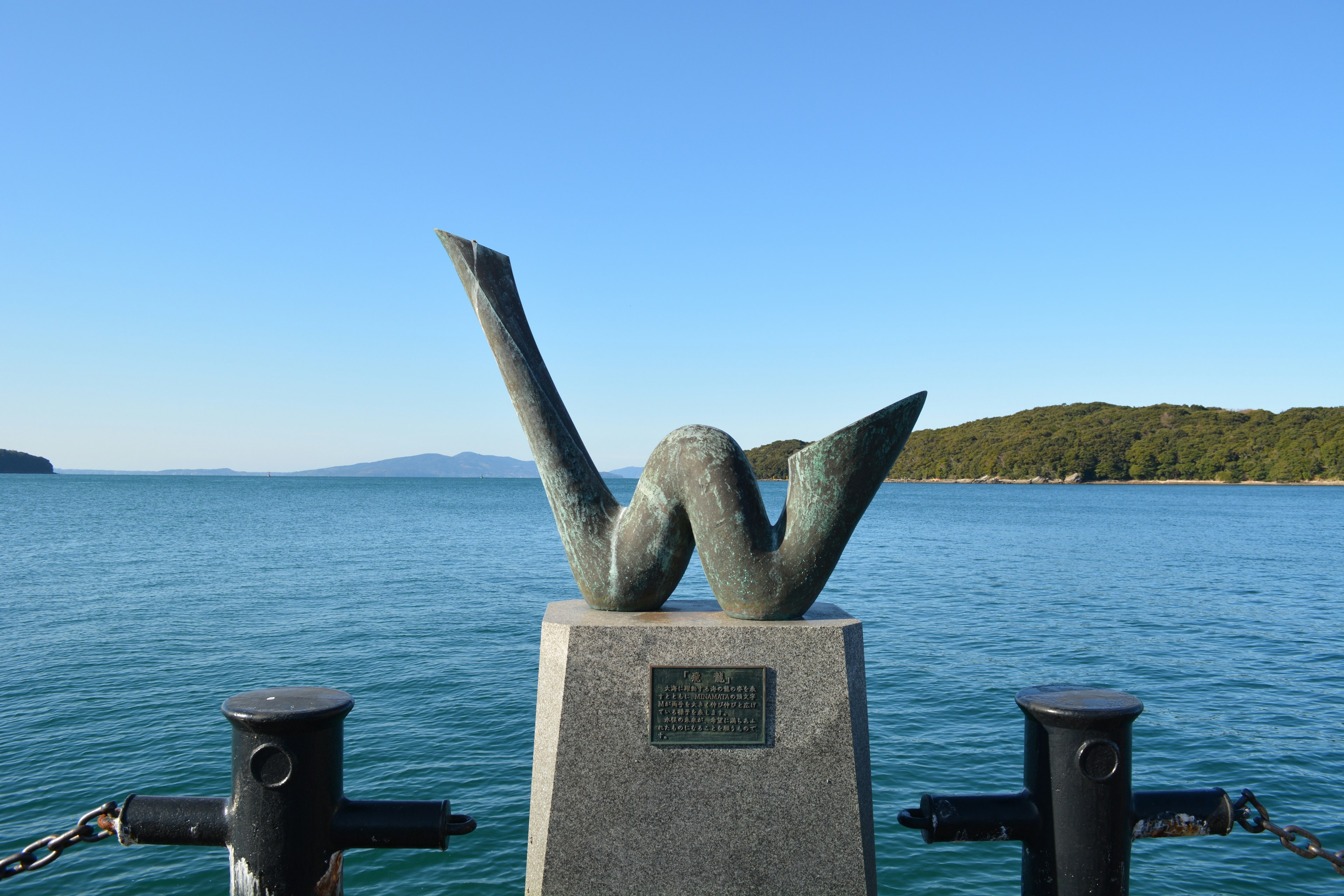 Sculpture évoquant des vagues sur fond de mer bleue