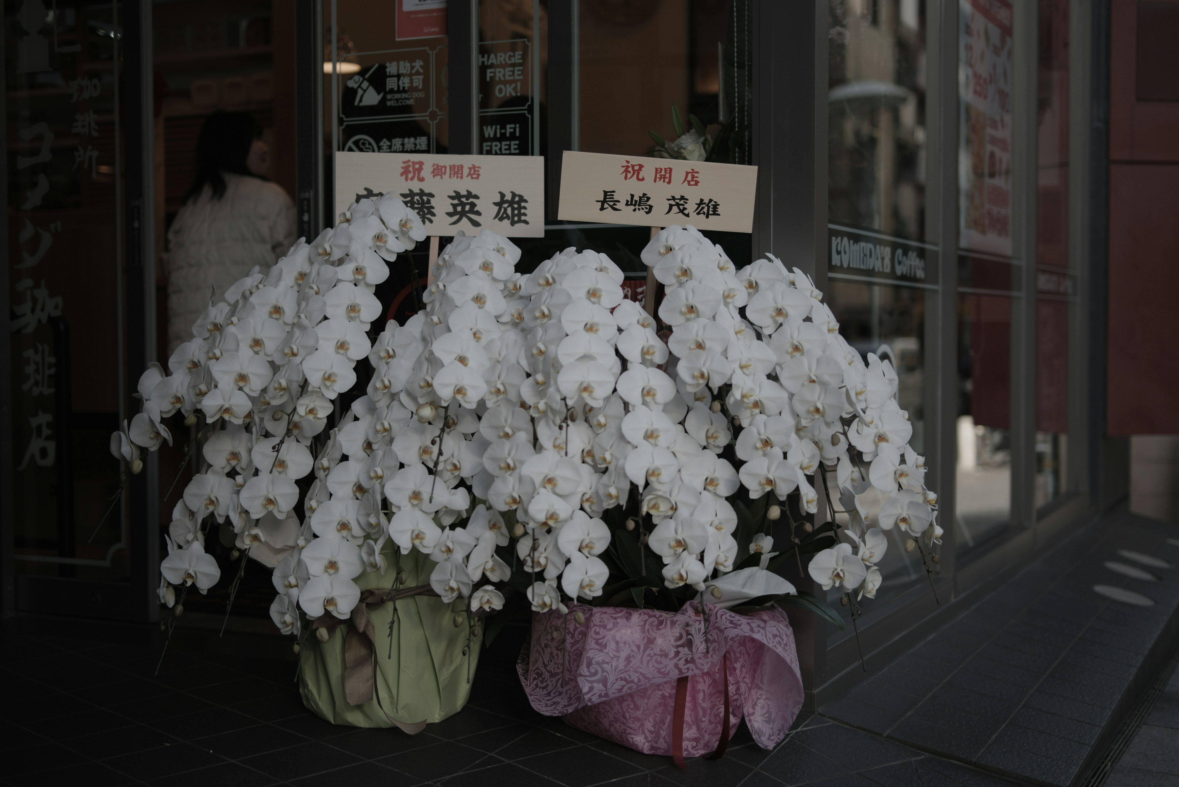 白い花の大きなアレンジメントが店舗の前に置かれている