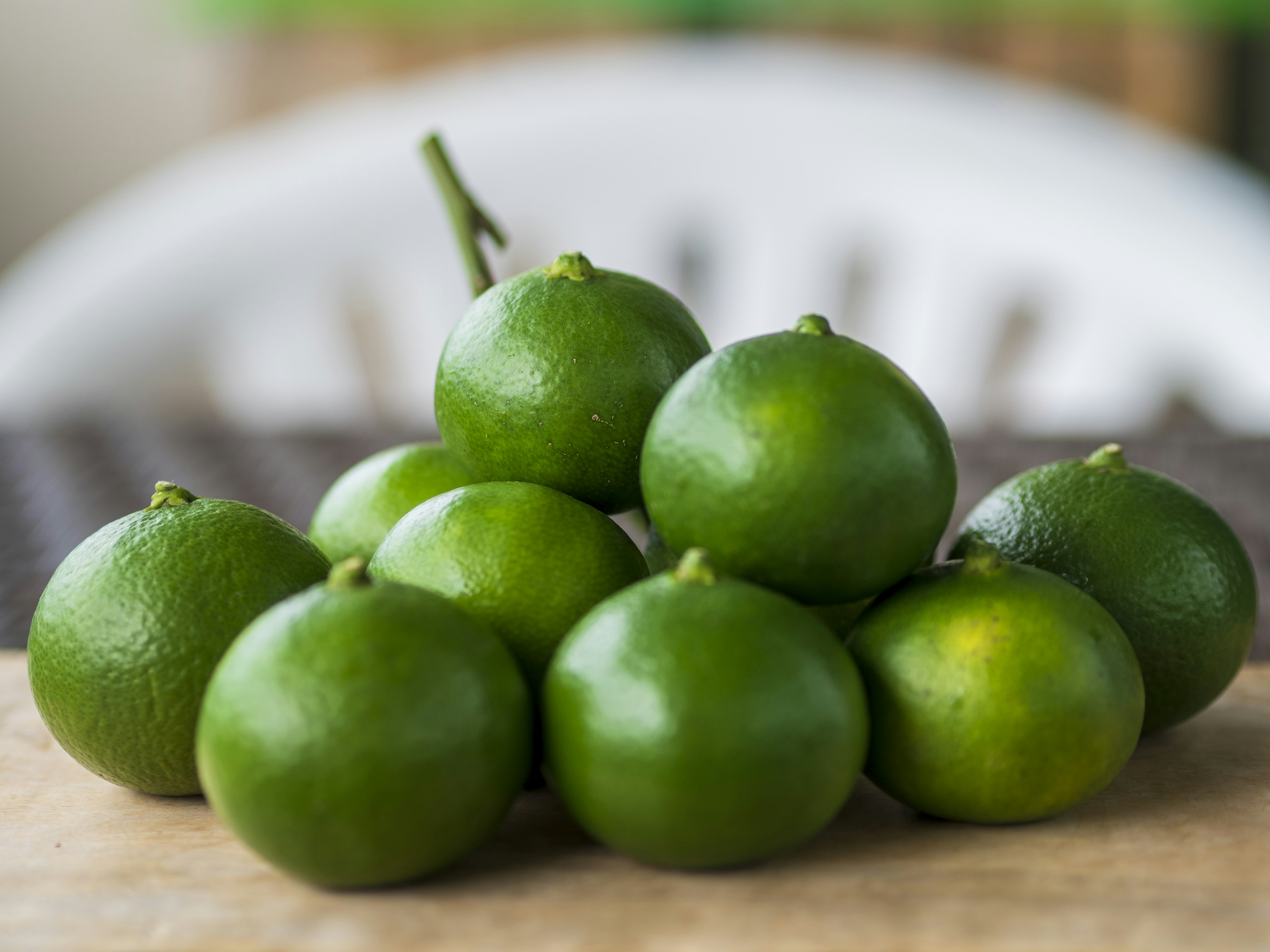 Una pila de limas verdes dispuestas sobre una superficie de madera