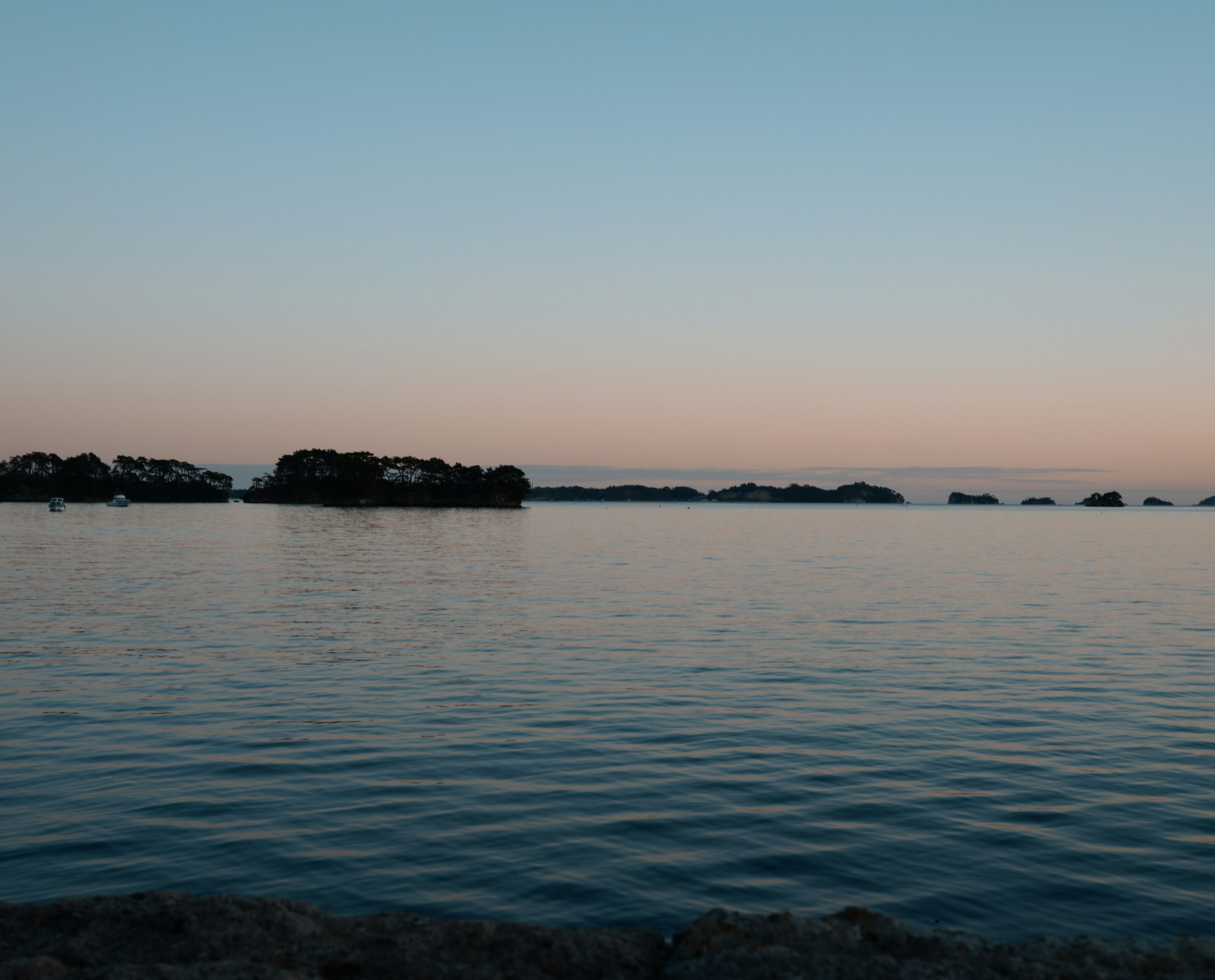 静かな水面と柔らかな空の色合いが美しい海の風景