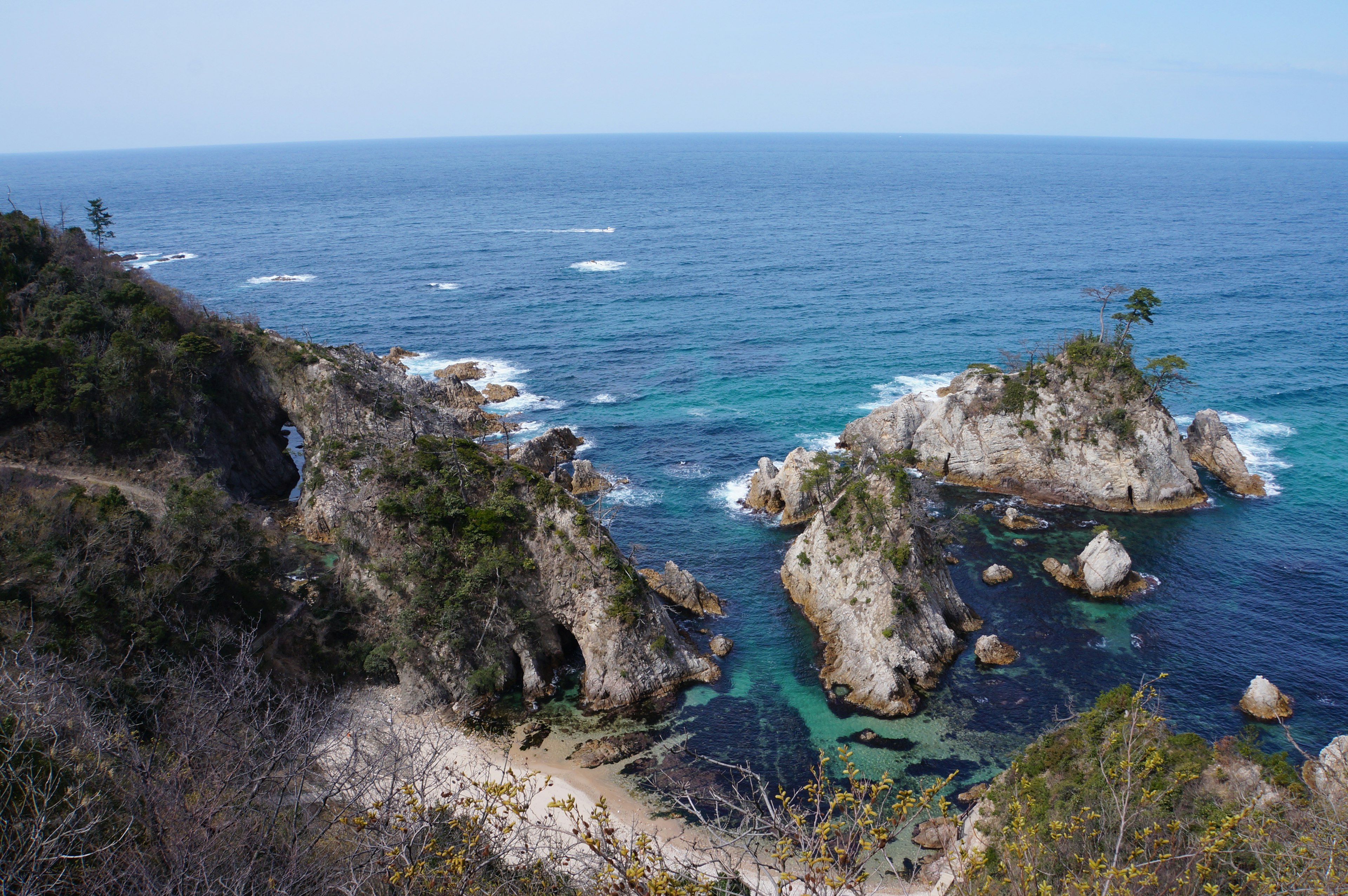 Scenic view of blue ocean with rocky formations and small islands