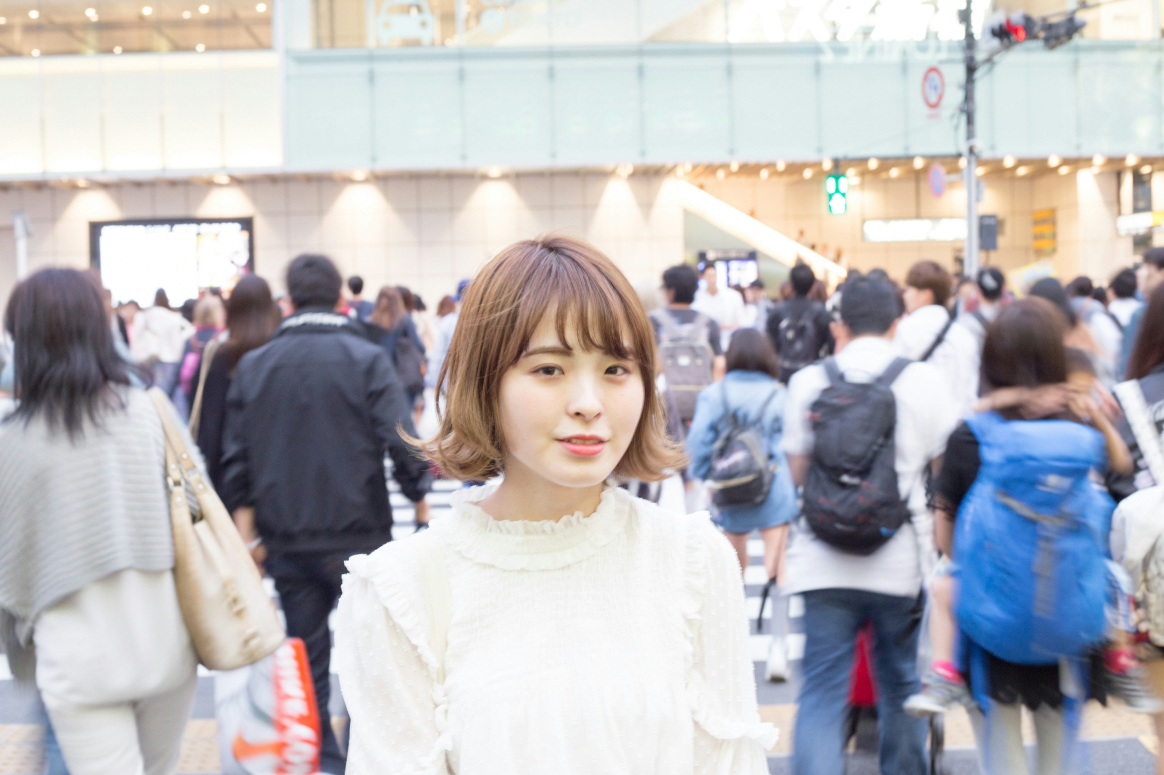 Portrait of a woman looking at the camera in a crowded intersection