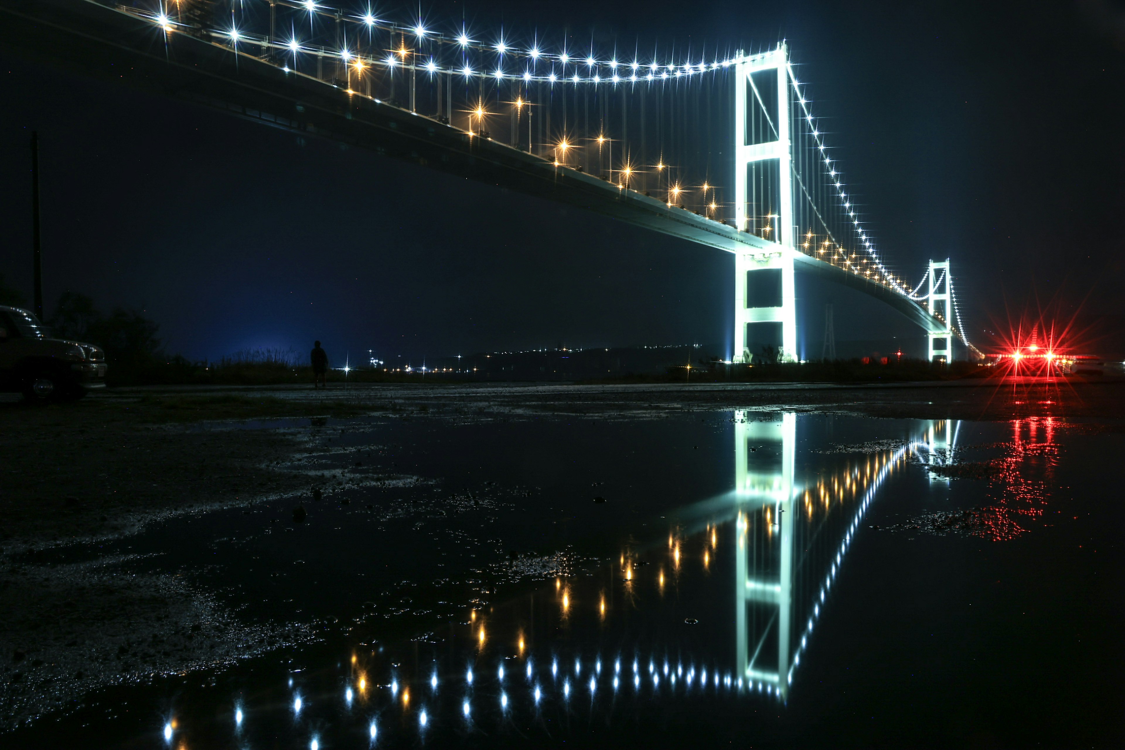 Ponte splendidamente illuminato di notte con riflessi sull'acqua