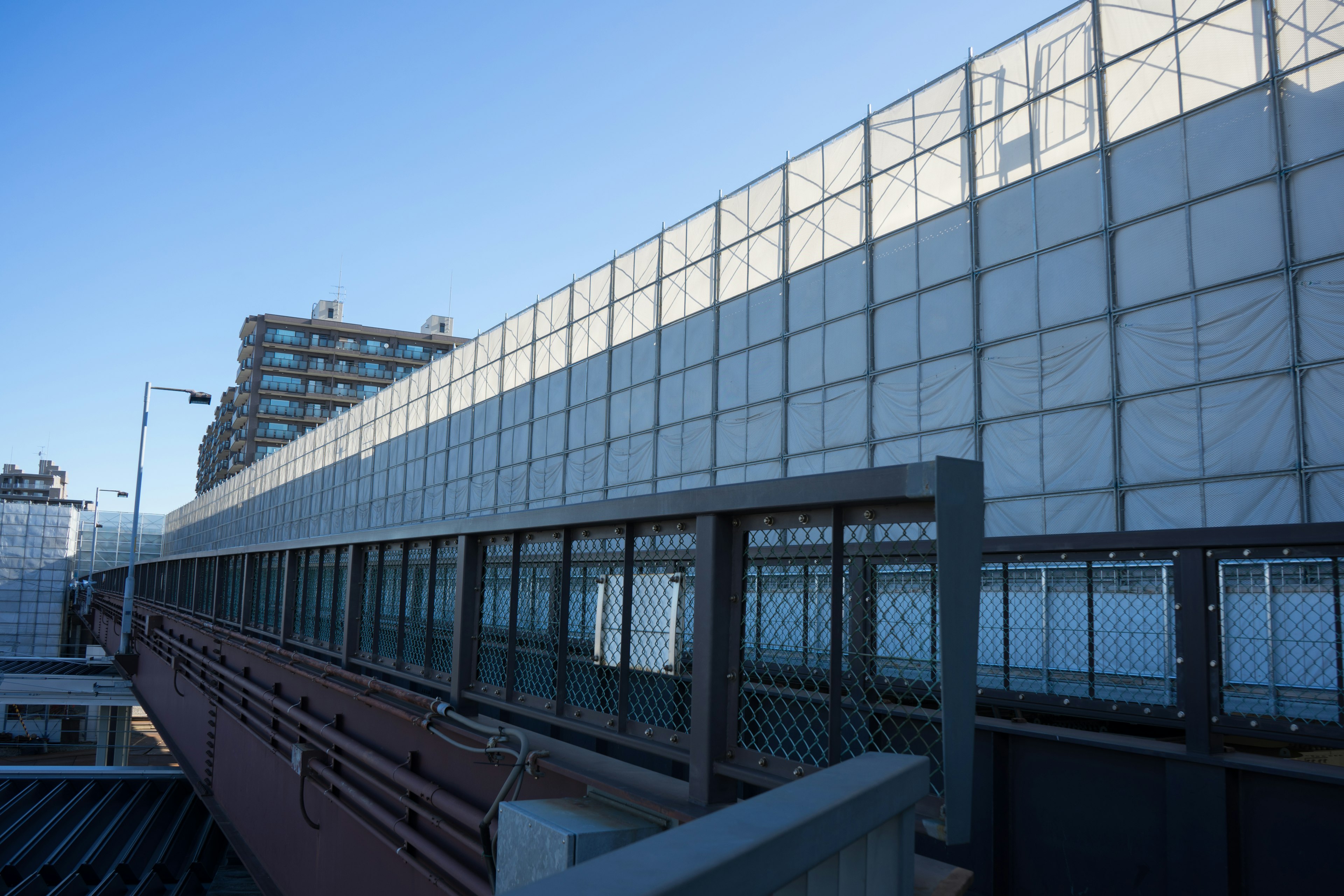 View of a high-rise building exterior with a glass fence