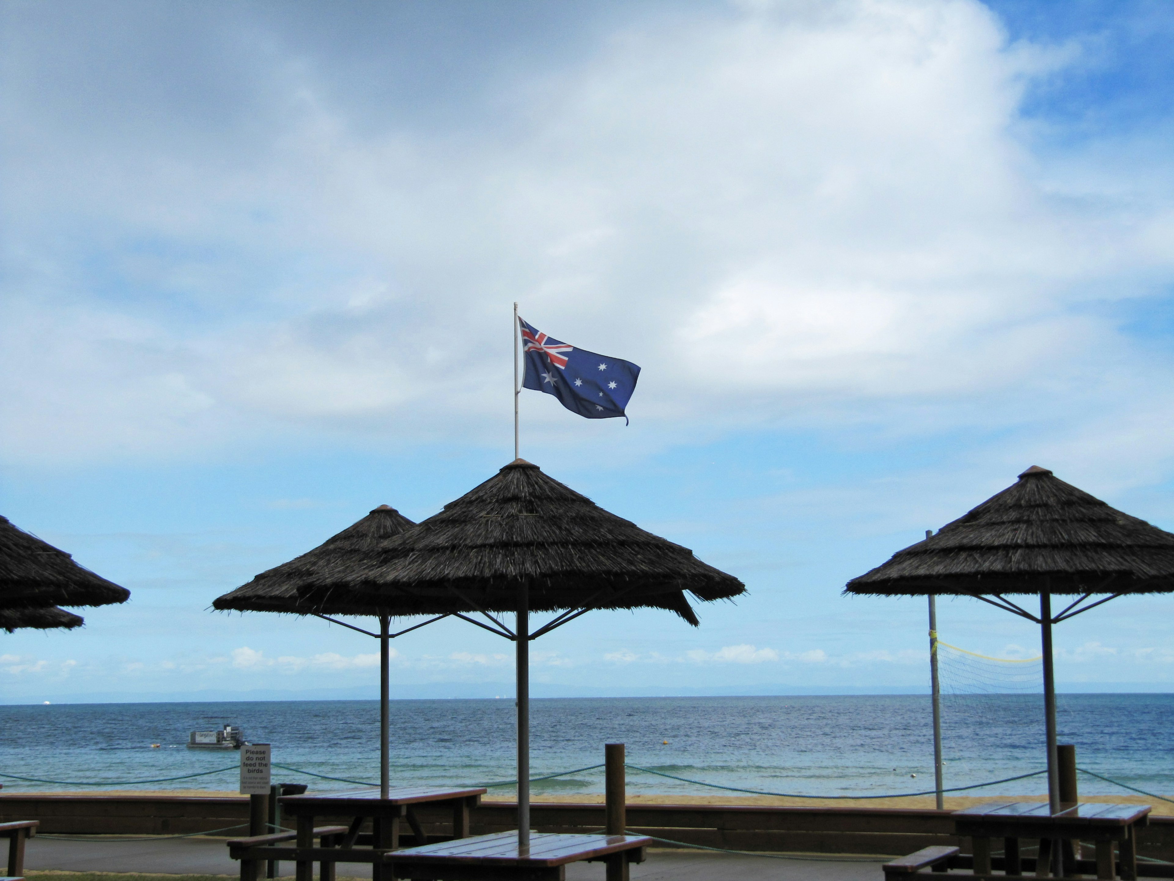 Sombrillas de playa con una bandera australiana bajo un cielo azul