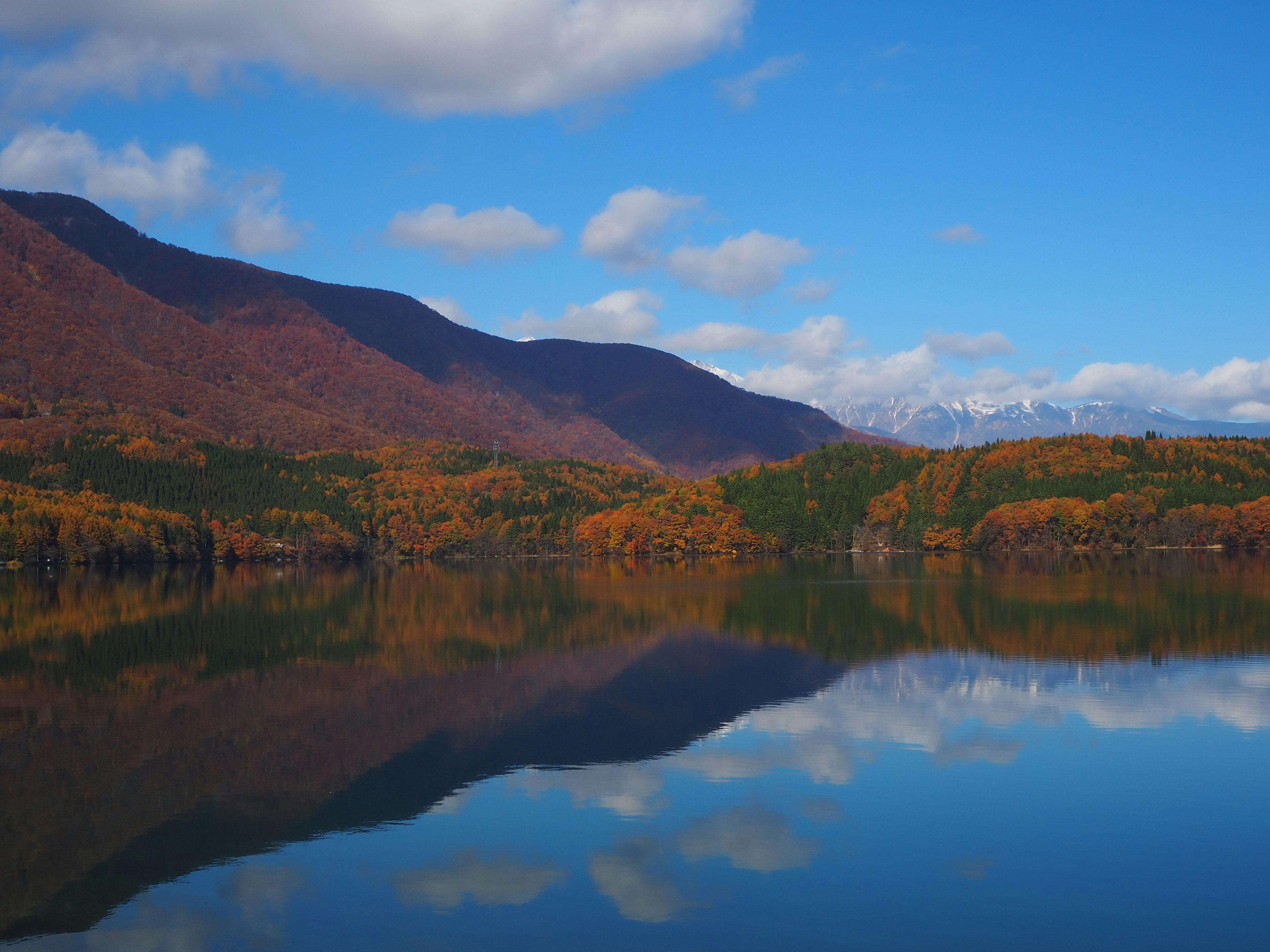 Paesaggio autunnale scenico con lago e riflessi delle montagne