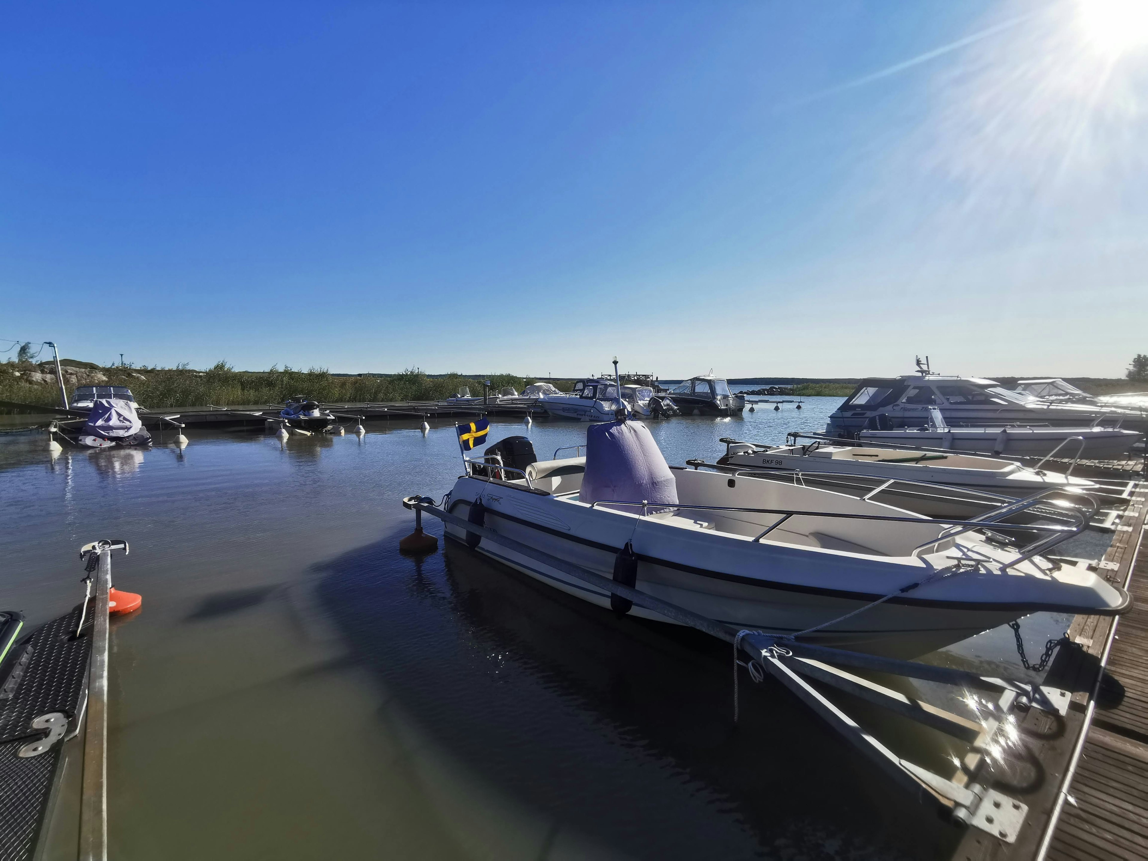 Scenic view of boats docked in a calm harbor on a sunny day