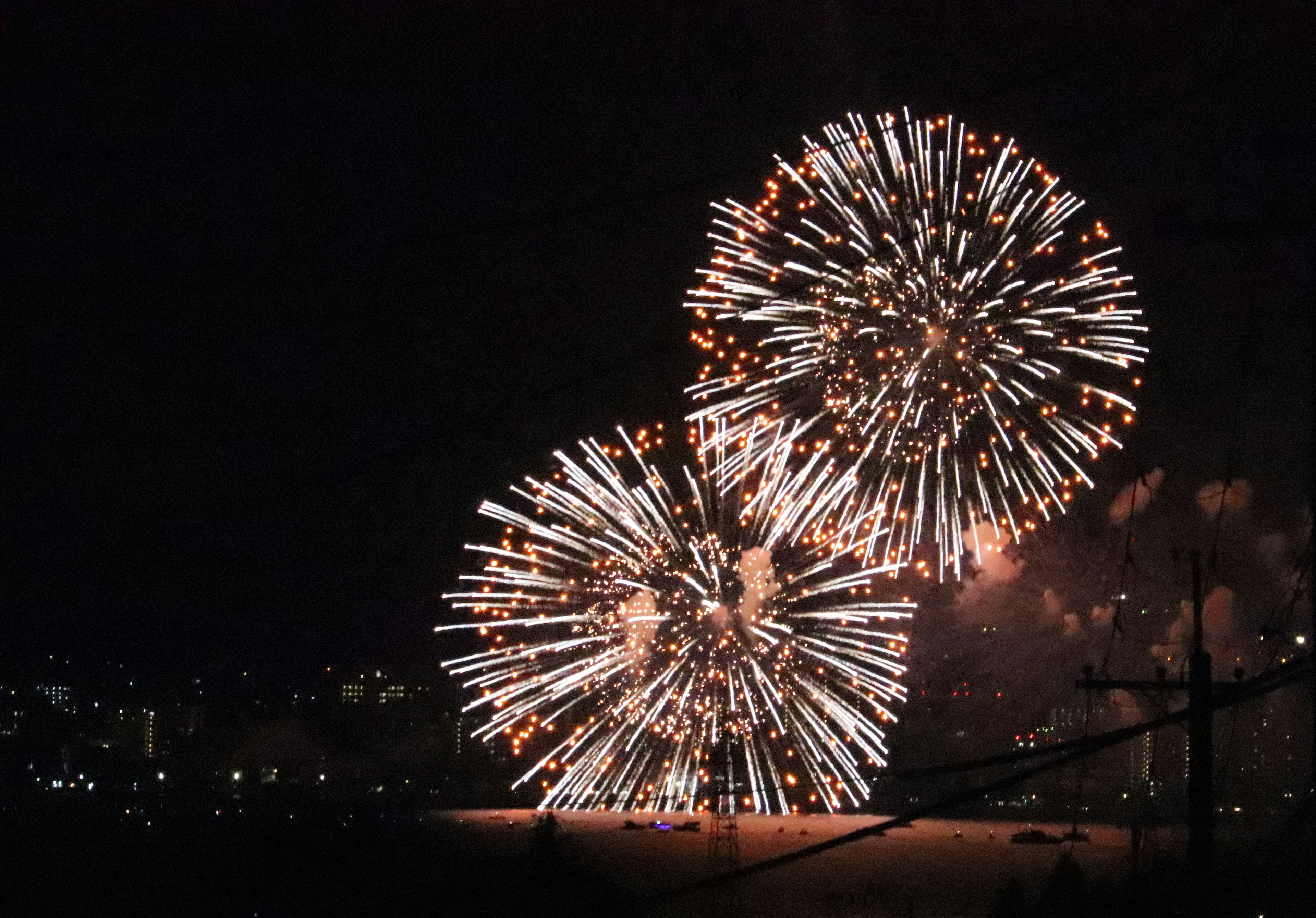 Two large fireworks bursting in the night sky