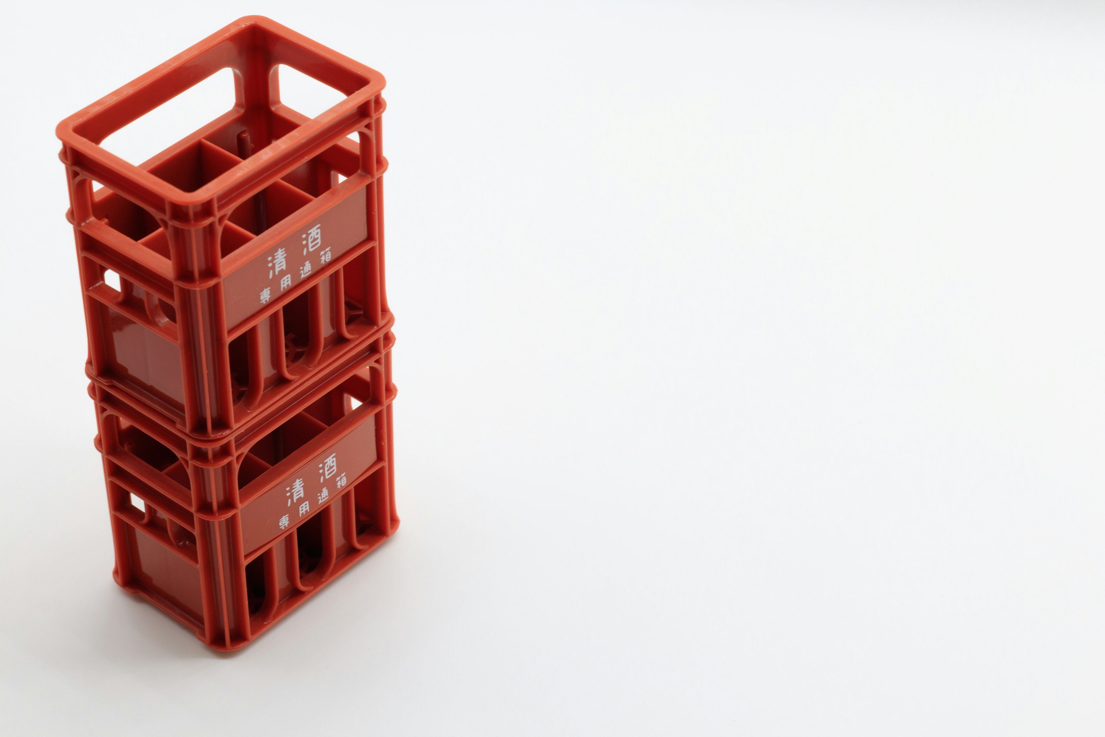 Two stacked red plastic crates on a white background