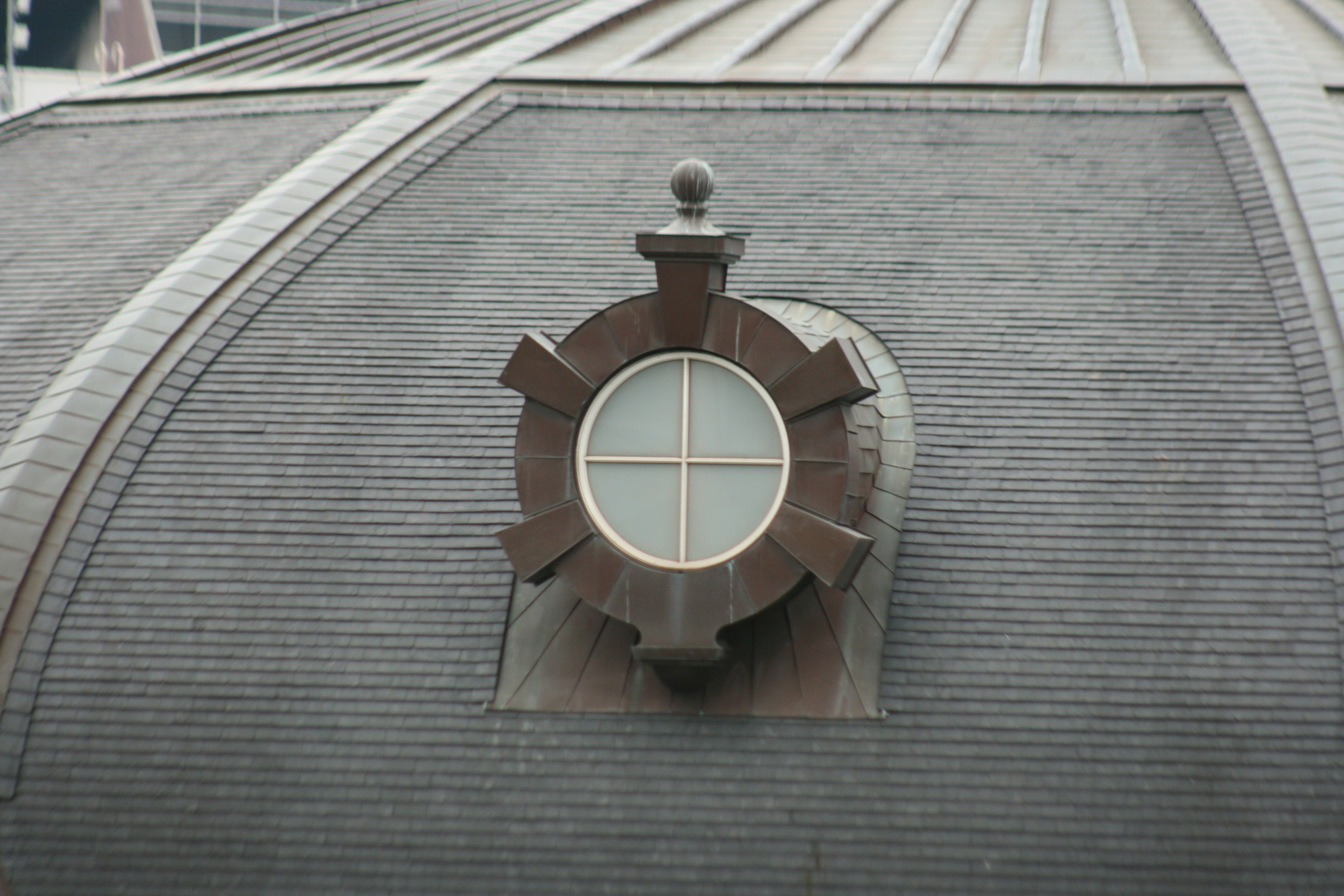 Ventana redonda decorativa en un techo inclinado