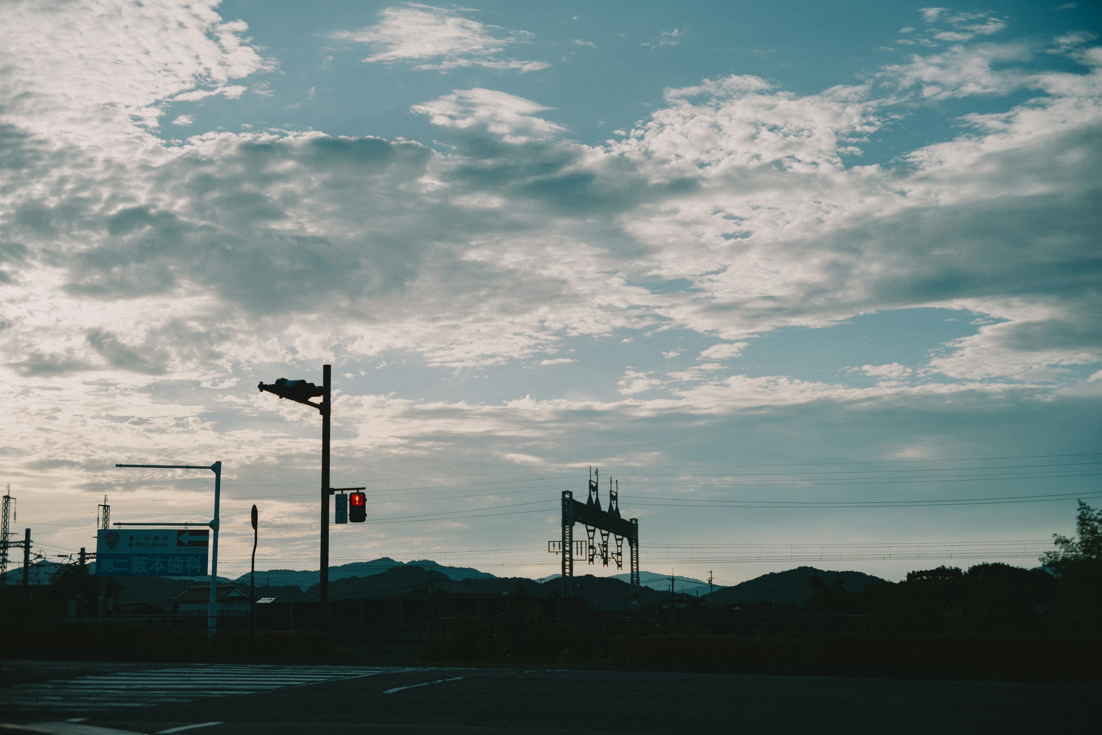 Landscape with traffic lights and billboards under a blue sky and clouds