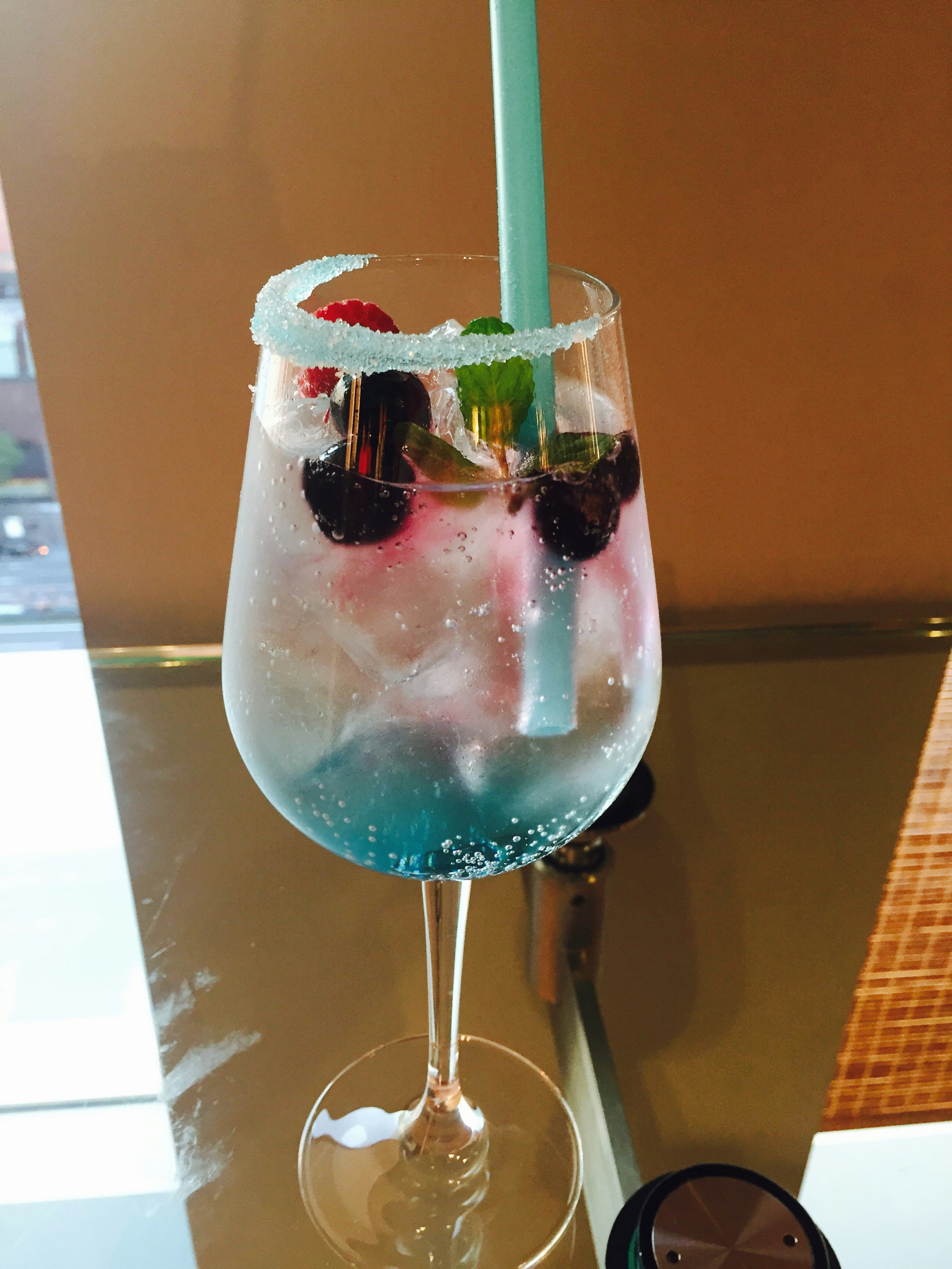 Colorful drink in a glass adorned with berries