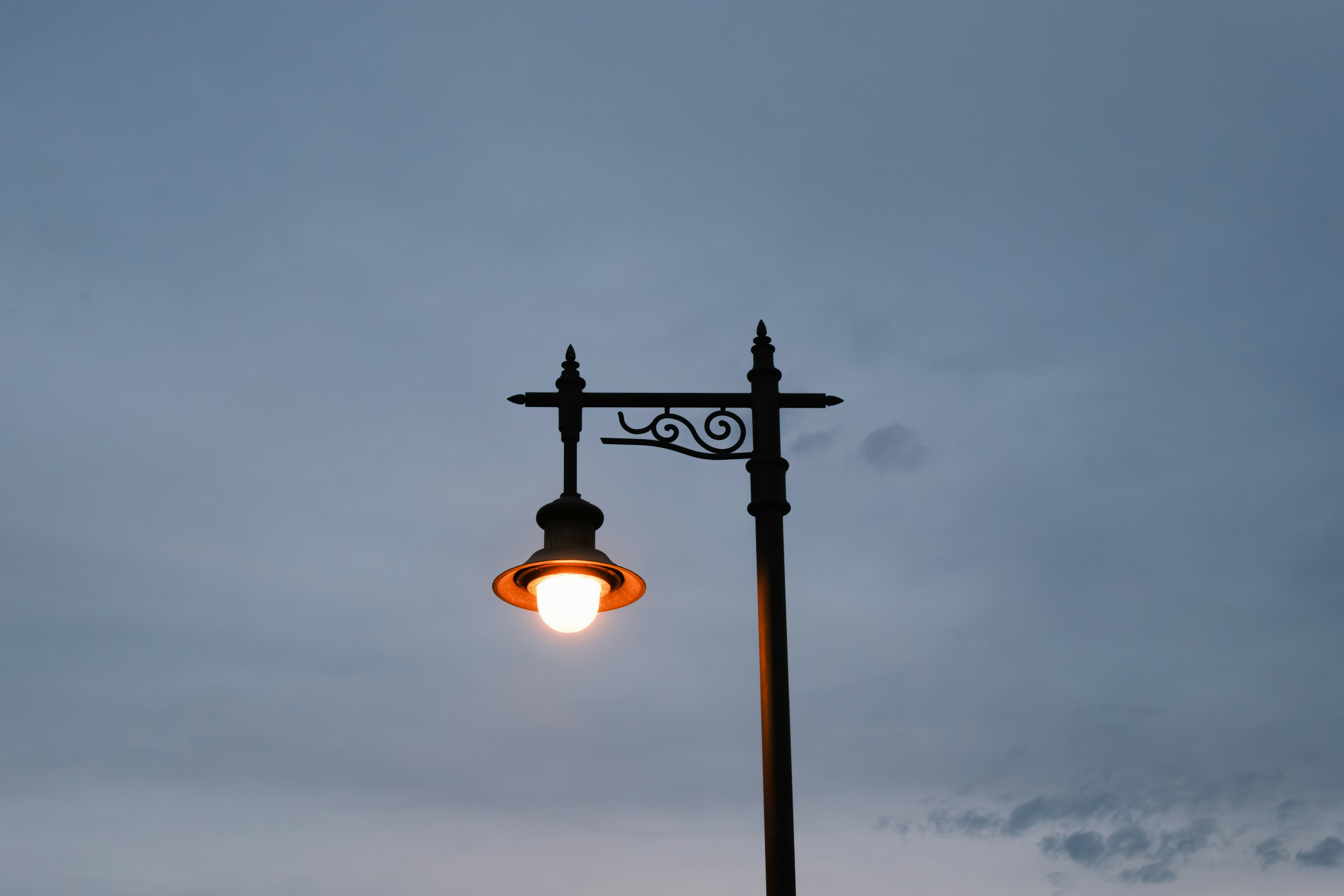 Vintage street lamp illuminated against a twilight sky