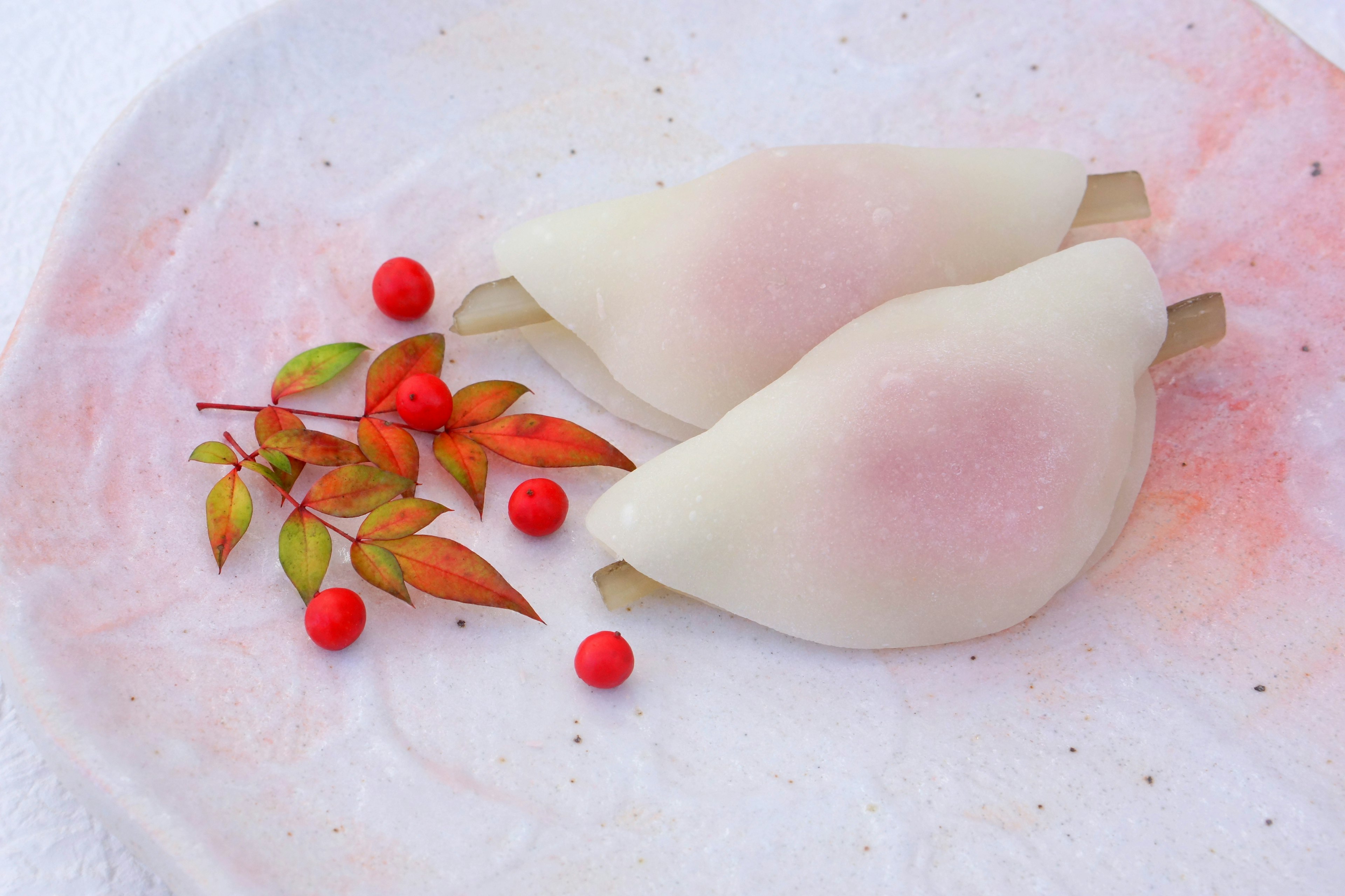 Dulces japoneses delicados dispuestos con hojas de otoño coloridas