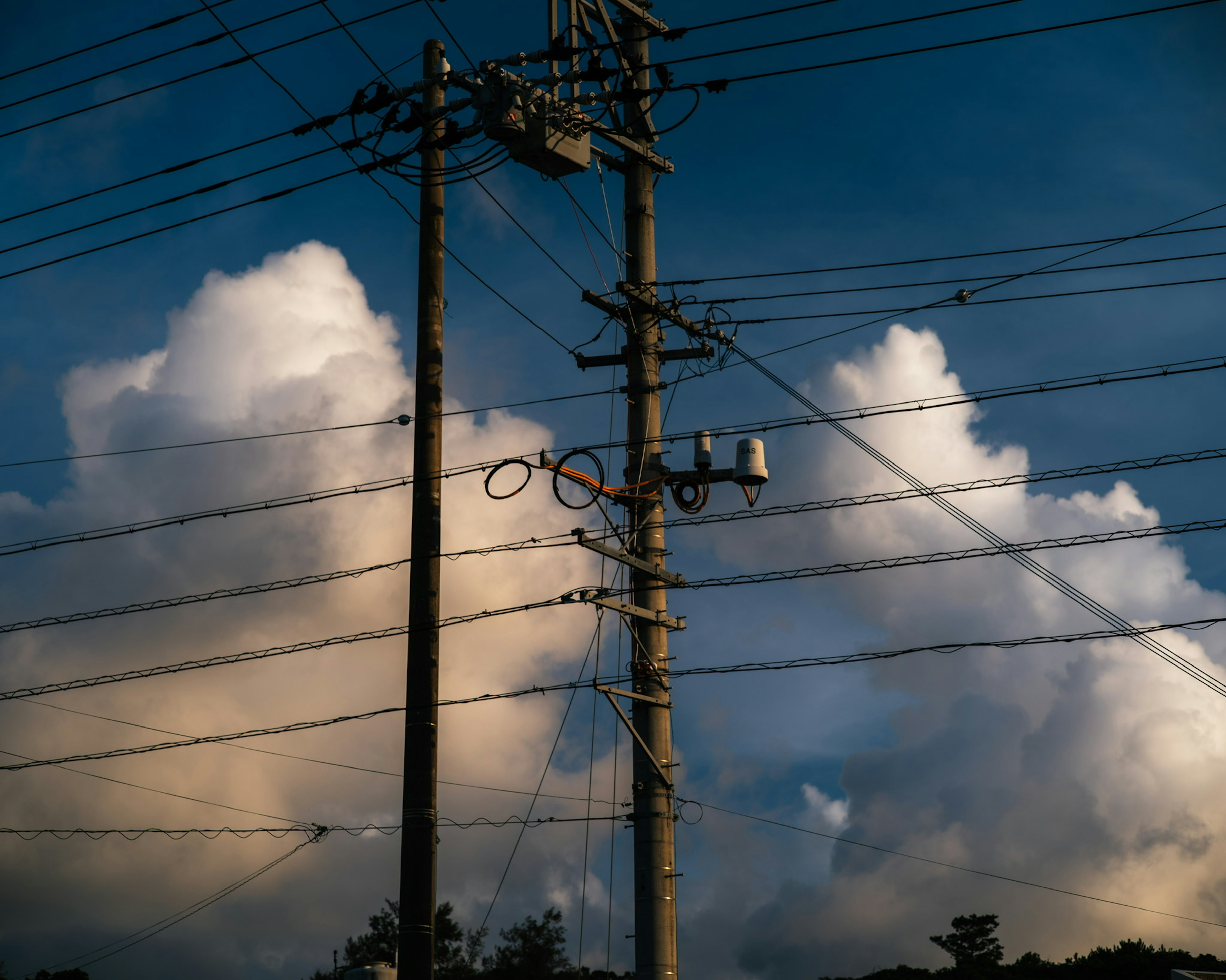 Postes de luz contra un fondo de cielo azul y nubes blancas