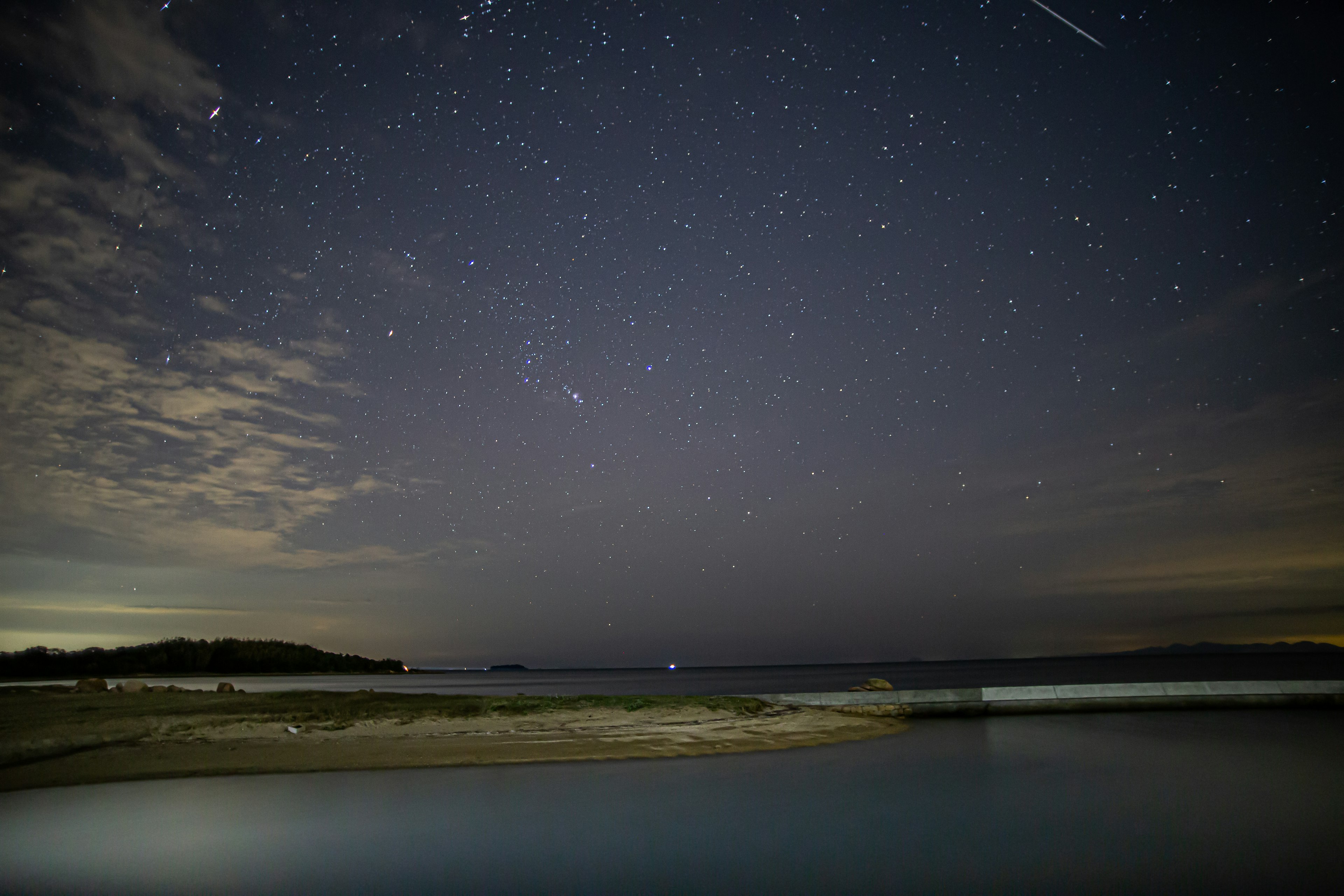 Cielo notturno pieno di stelle sopra una calma spiaggia